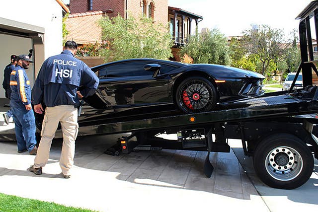 <p>Special agents with HSI Los Angeles's El Camino Real Financial Crimes Task Force seize a Lamborghini from an Orange County businessman on Thursday, April 6, 2021, in Irvine, California </p>
