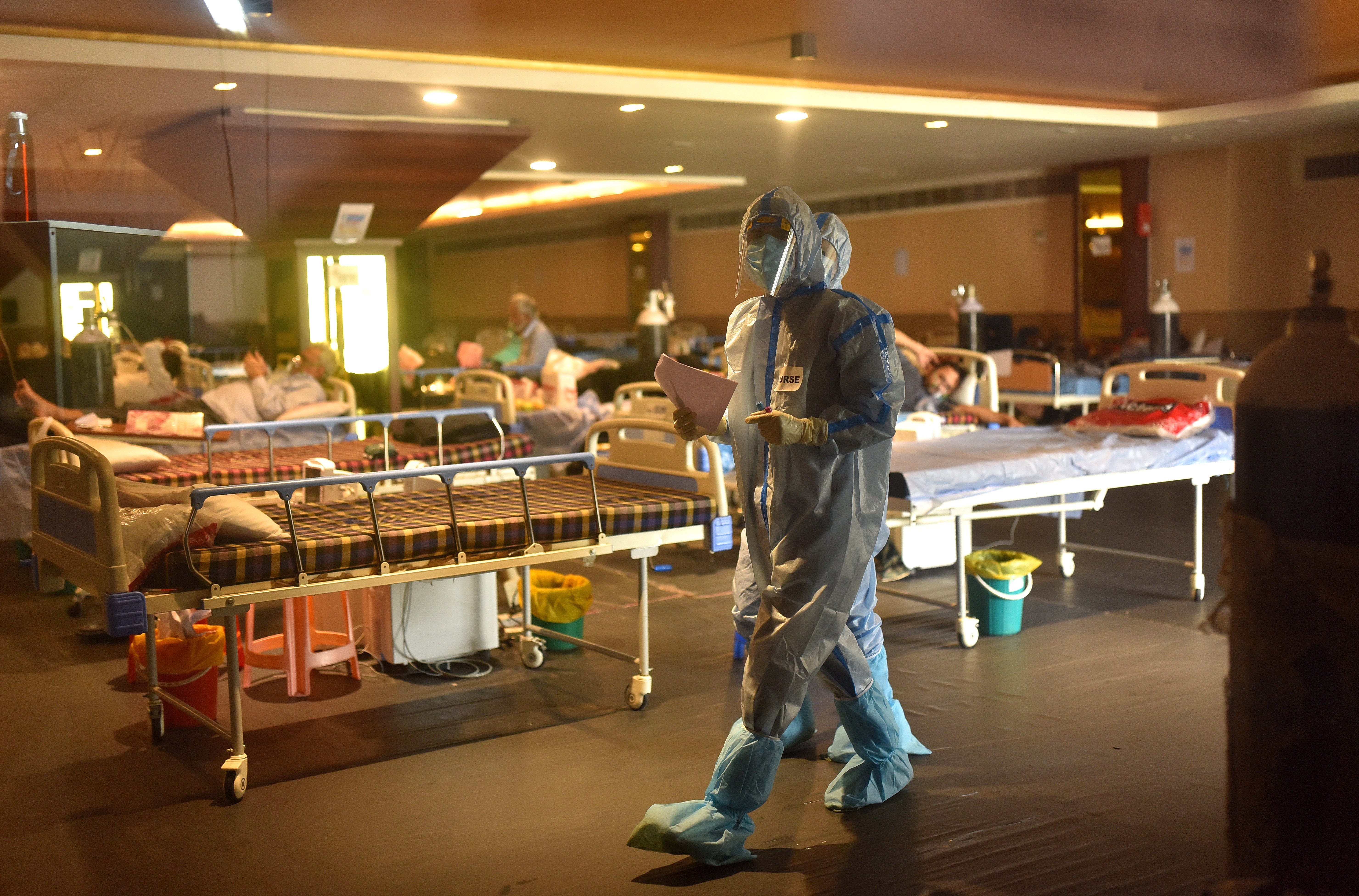 Doctors wearing Personal Protective Equipment (PPE) walk after examining patients inside a COVID-19 care center and isolation ward facility near a Hospital in New Delhi, India, as the country struggles in the grip of an unprecedented health crisis amid Covid-19 pandemic and vaccine shortages