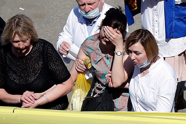 A woman cries as she is taken to an ambulance at the scene of a shooting at School No. 175 in Kazan