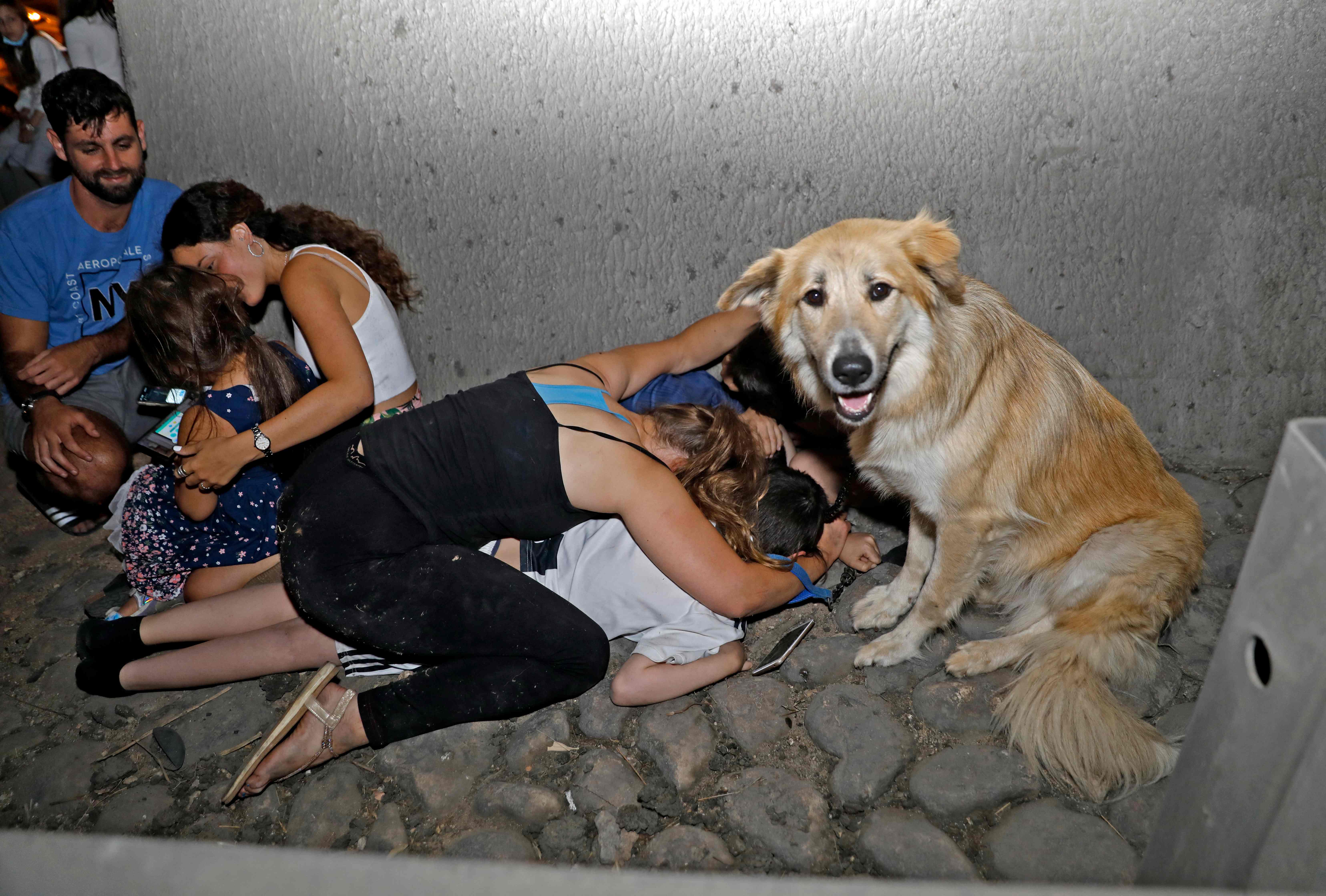 Israelis take cover under a bridge in Tel Aviv after rockets were launched from the Gaza Strip