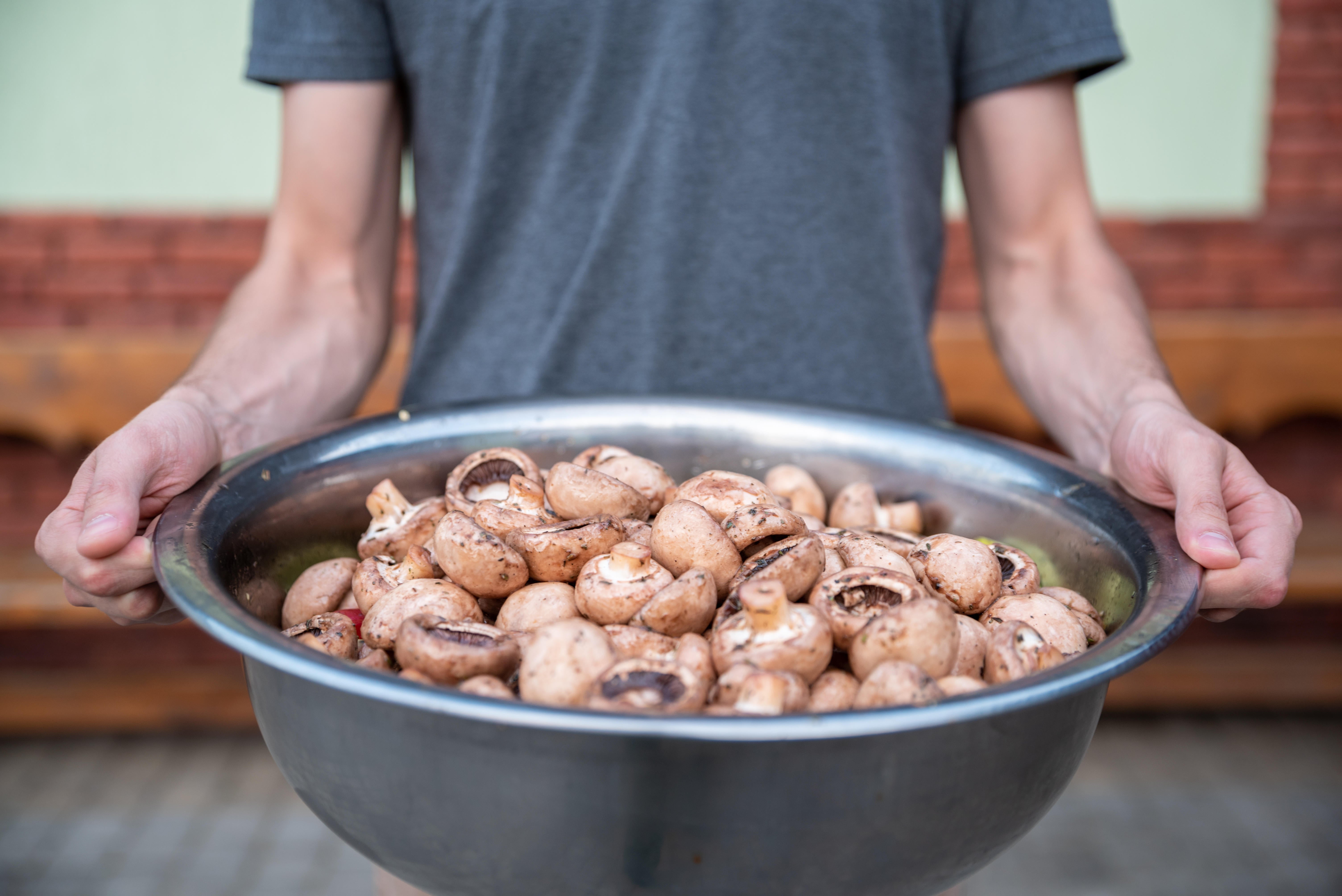 Man holding a big bowl of mushrooms
