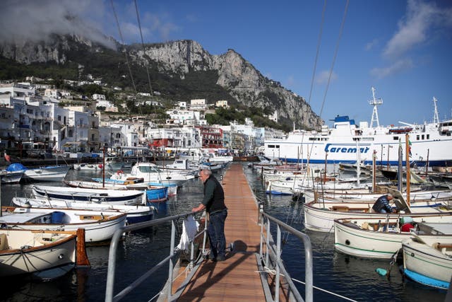 <p>A man looks on in Marina Grande, the main port of the island of Capri, on 28 April, 2021. </p>