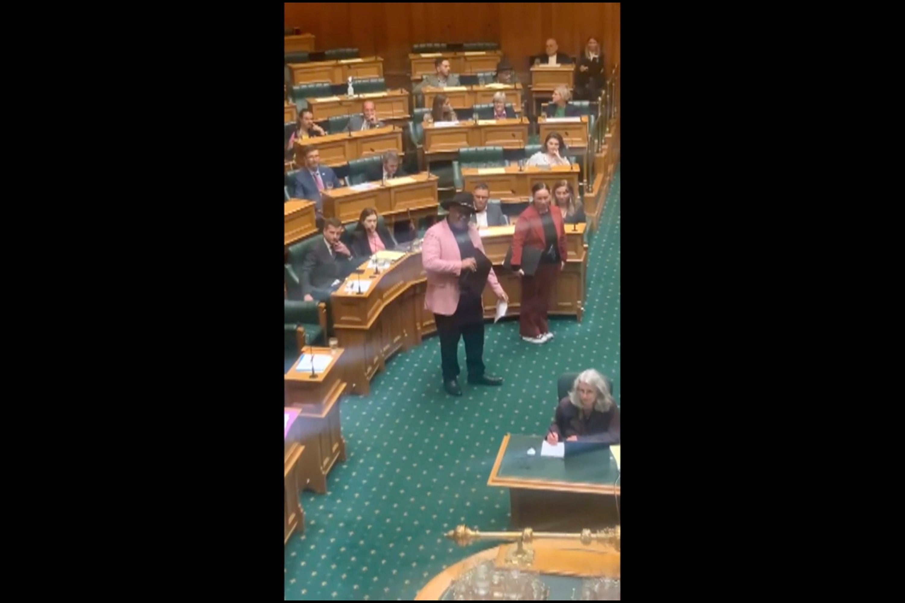 In this screengrab from video, indigenous New Zealand lawmaker Rawiri Waititi, centre, performs a Maori haka in Parliament in Wellington on 12 May, 2021