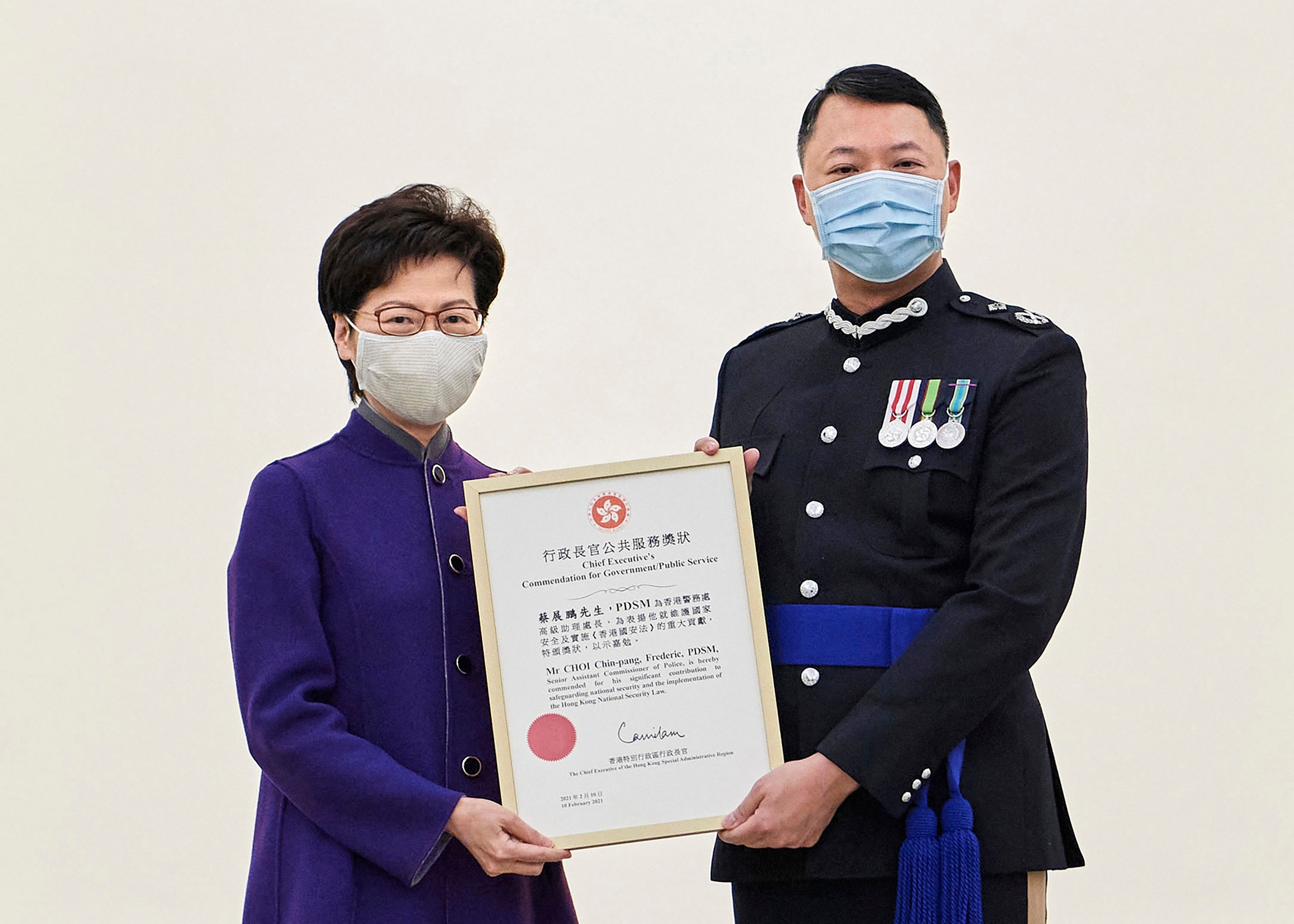 Hong Kong Chief Executive Carrie Lam, left, presents the award to Hong Kong's Director of National Security Frederic Choi