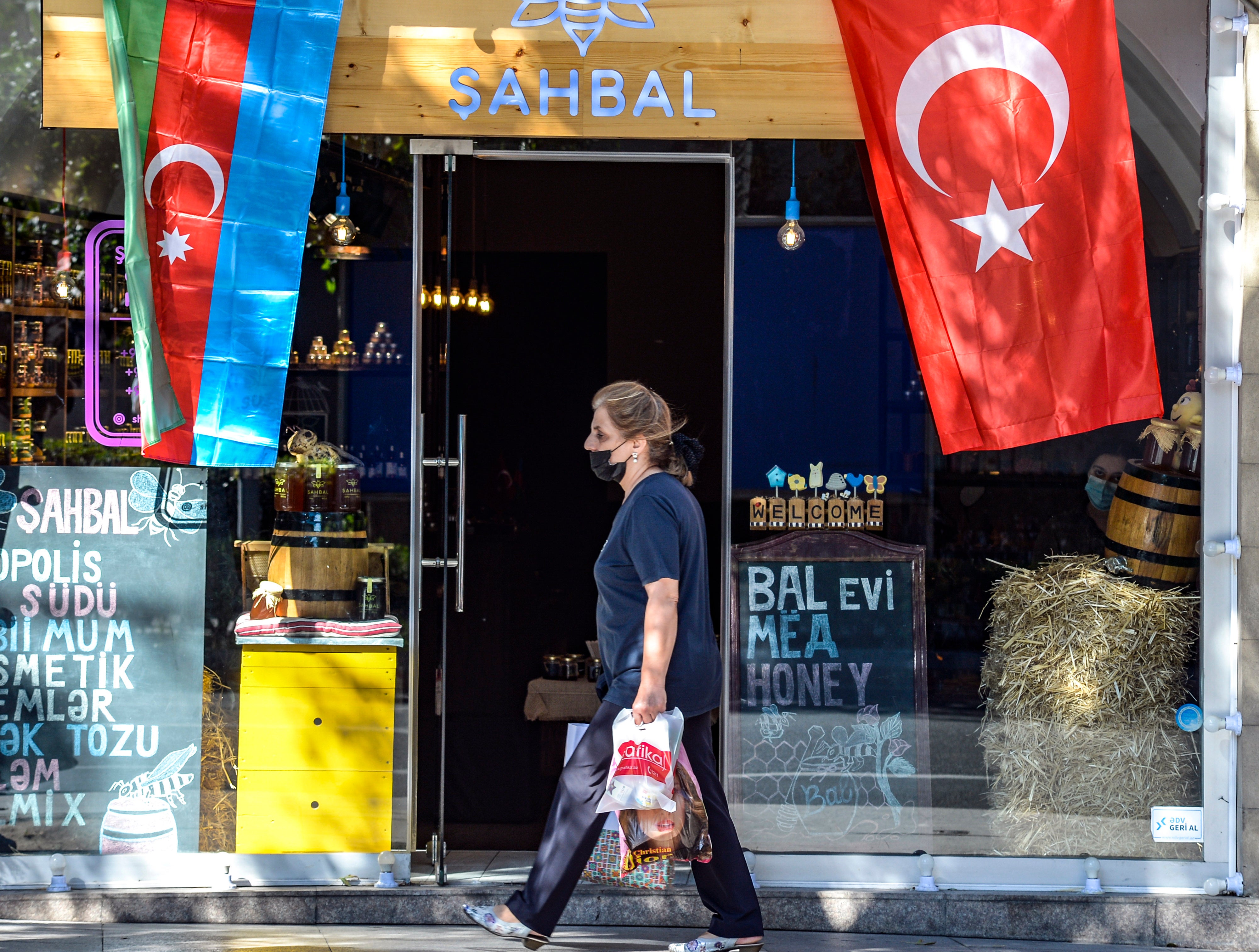 Woman strolls past shop in Azerbaijani capital of Baku
