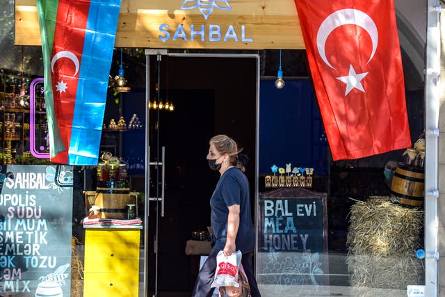 <p>Woman strolls past shop in Azerbaijani capital of Baku </p>