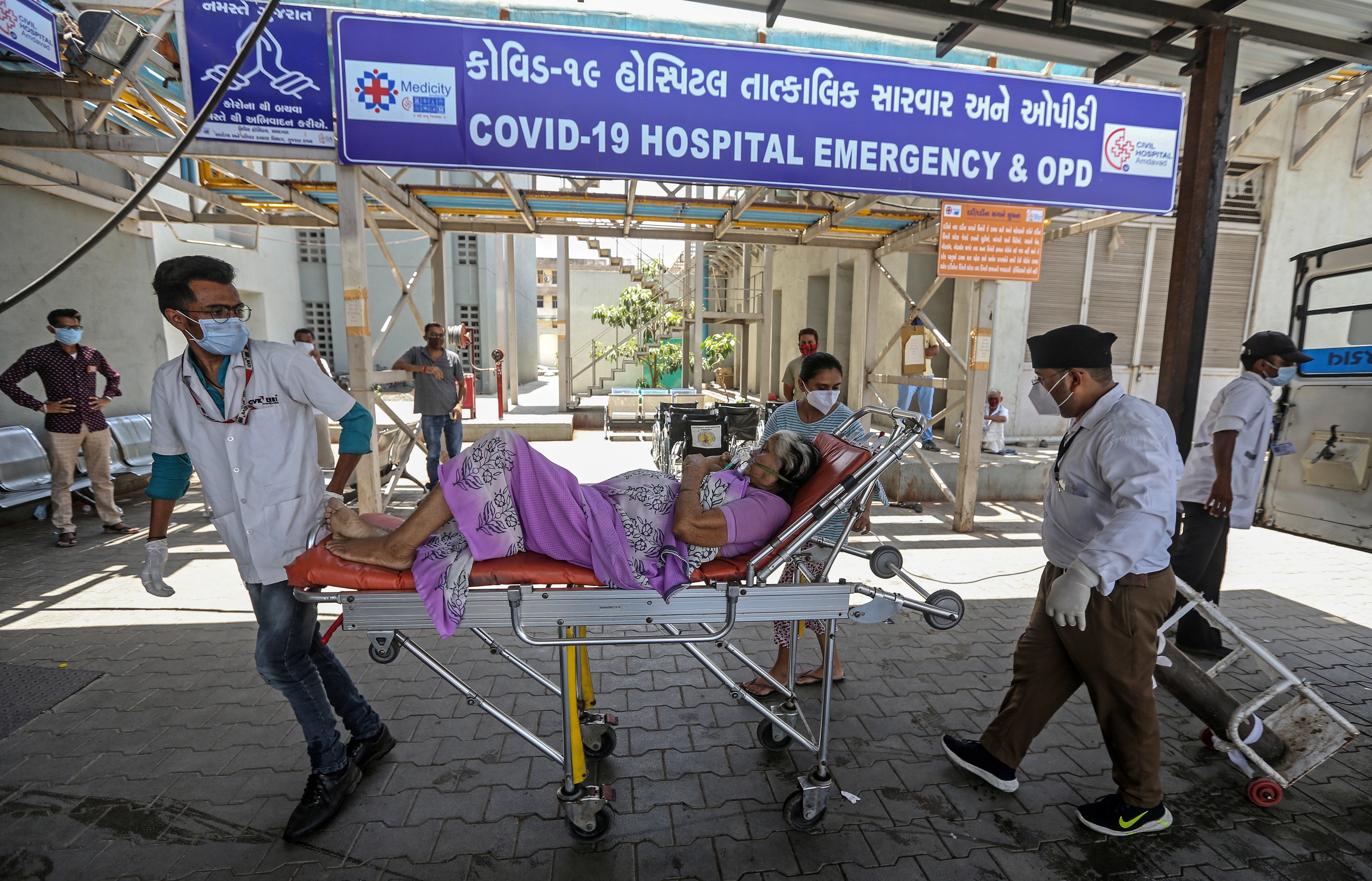 Indian health workers bring a suspected Covid-19 positive patient into a hospital in Ahmedabad, India