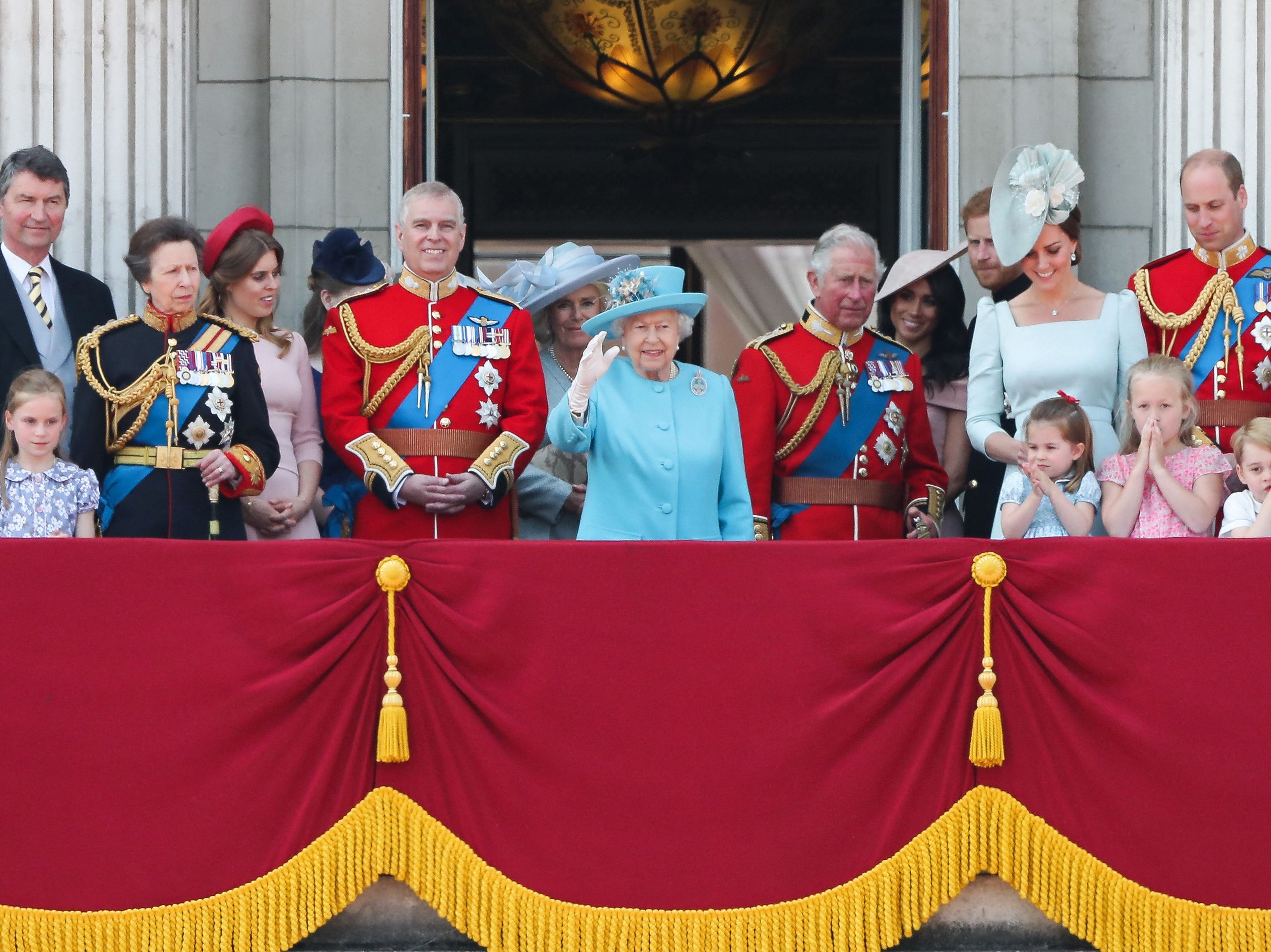 Members of the Royal Family (L-R) Vice Admiral Timothy Laurence, Britain's Princess Anne, Princess Royal, Britain's Princess Beatrice of York, Britain's Prince Andrew, Duke of York, Britain's Camilla, Duchess of Cornwall, Britain's Queen Elizabeth II, Britain's Prince Charles, Prince of Wales, Britain's Meghan, Duchess of Sussex, Britain's Prince Harry, Duke of Sussex, Britain's Catherine, Duchess of Cambridge (with Princess Charlotte and Prince George) and Britain's Prince William, Duke of Cambridge, stand on the balcony of Buckingham Palace to watch a fly-past of aircraft by the Royal Air Force