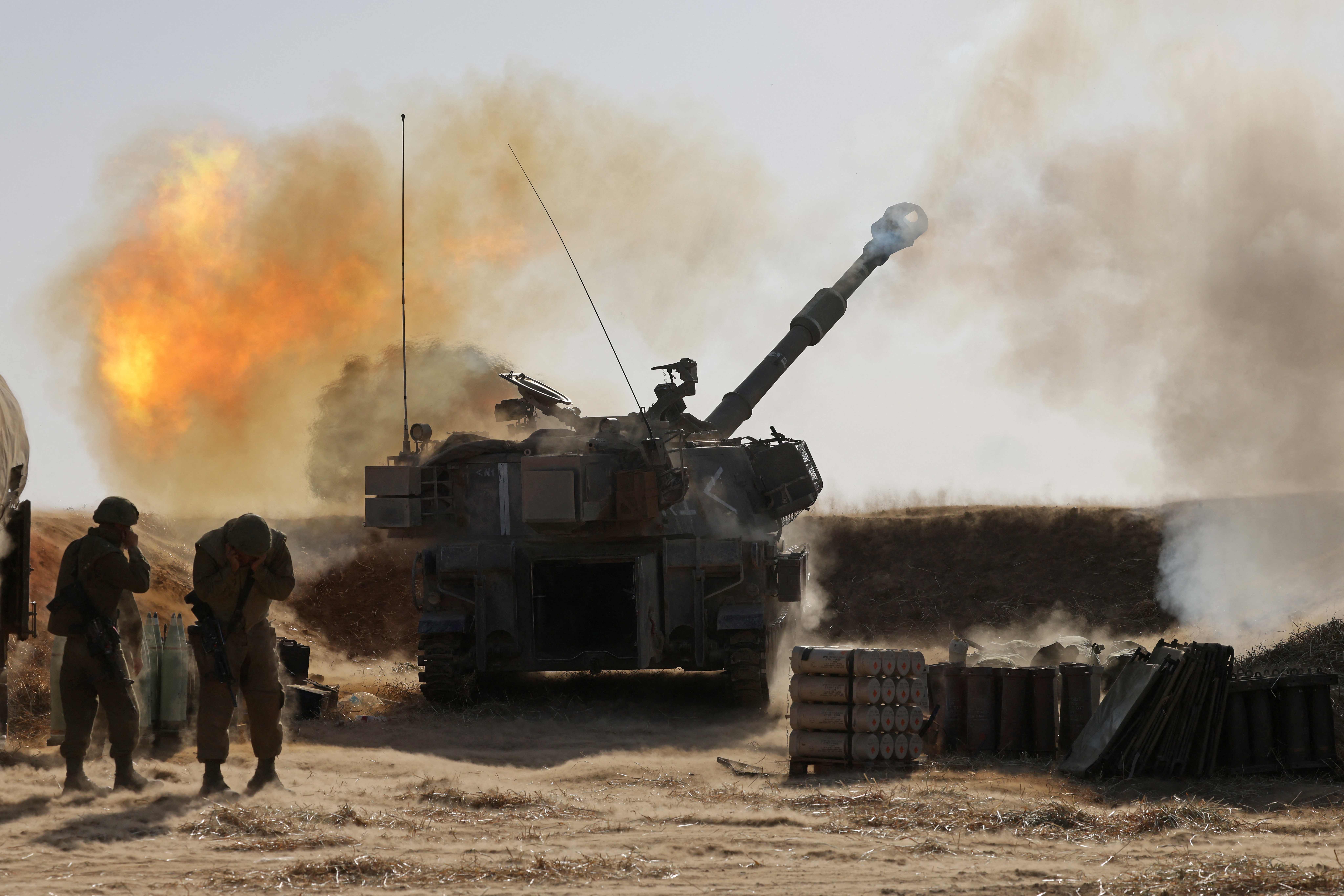 Israeli soldiers fire a 155mm self-propelled howitzer towards targets in the Gaza Strip from their position near the western Israeli city of Sderot