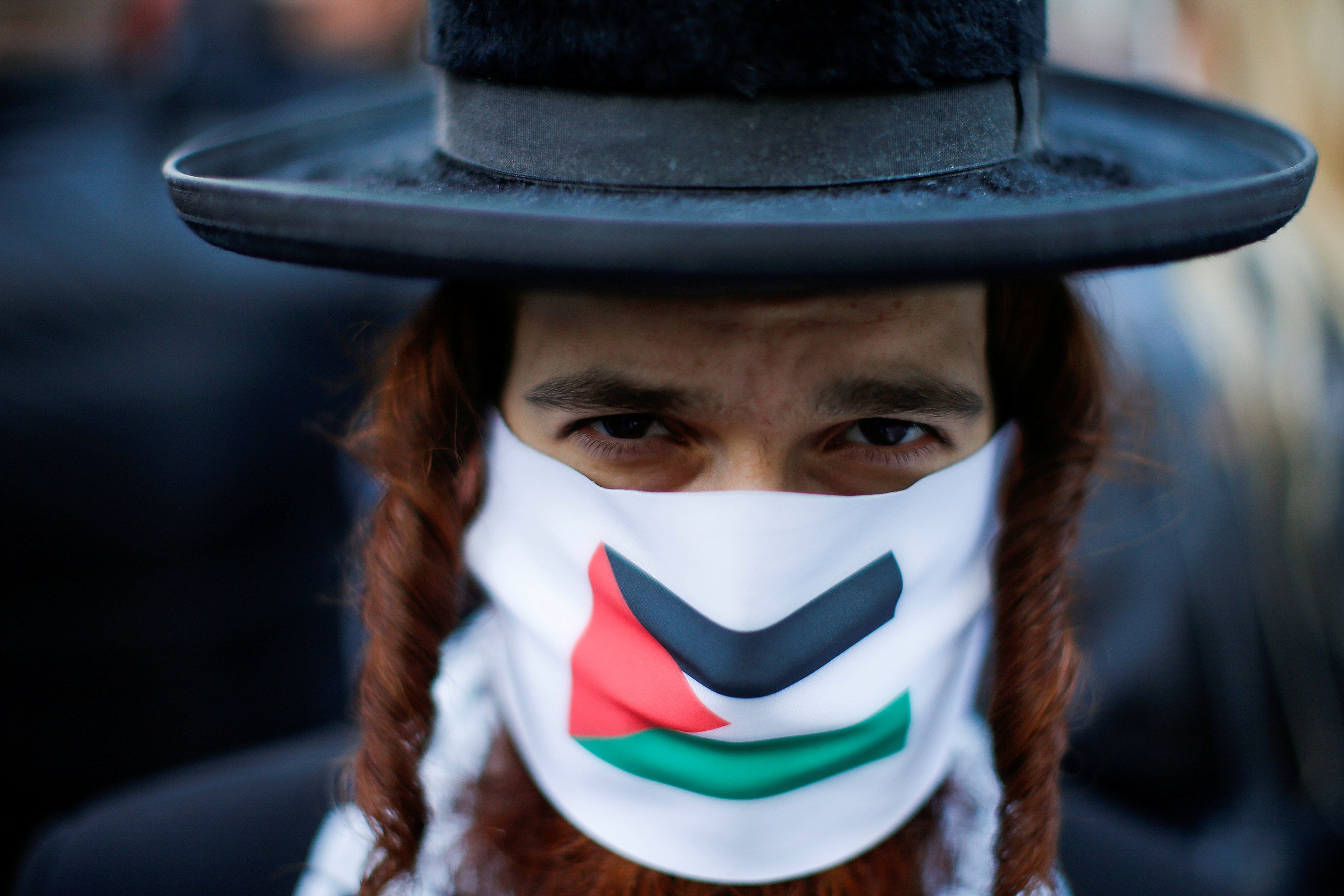 A pro-Palestinian Jewish Orthodox wears a face mask during a protest near the Israeli Consulate following a flare-up of Israeli-Palestinian violence in Manhattan