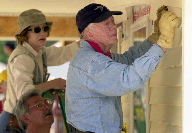 <p>Former US president Jimmy Carter and his wife Rosalynn attach siding to the front of a Habitat for Humanity home built on  June 10, 2003, in LaGrange, Georgia</p>