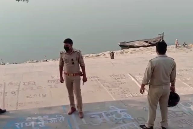 <p>Frame grab from video provided by KK Productions shows police officials stand at the banks of the river where several bodies were found in Ghazipur district in Uttar Pradesh on 11 May, 2021.</p>