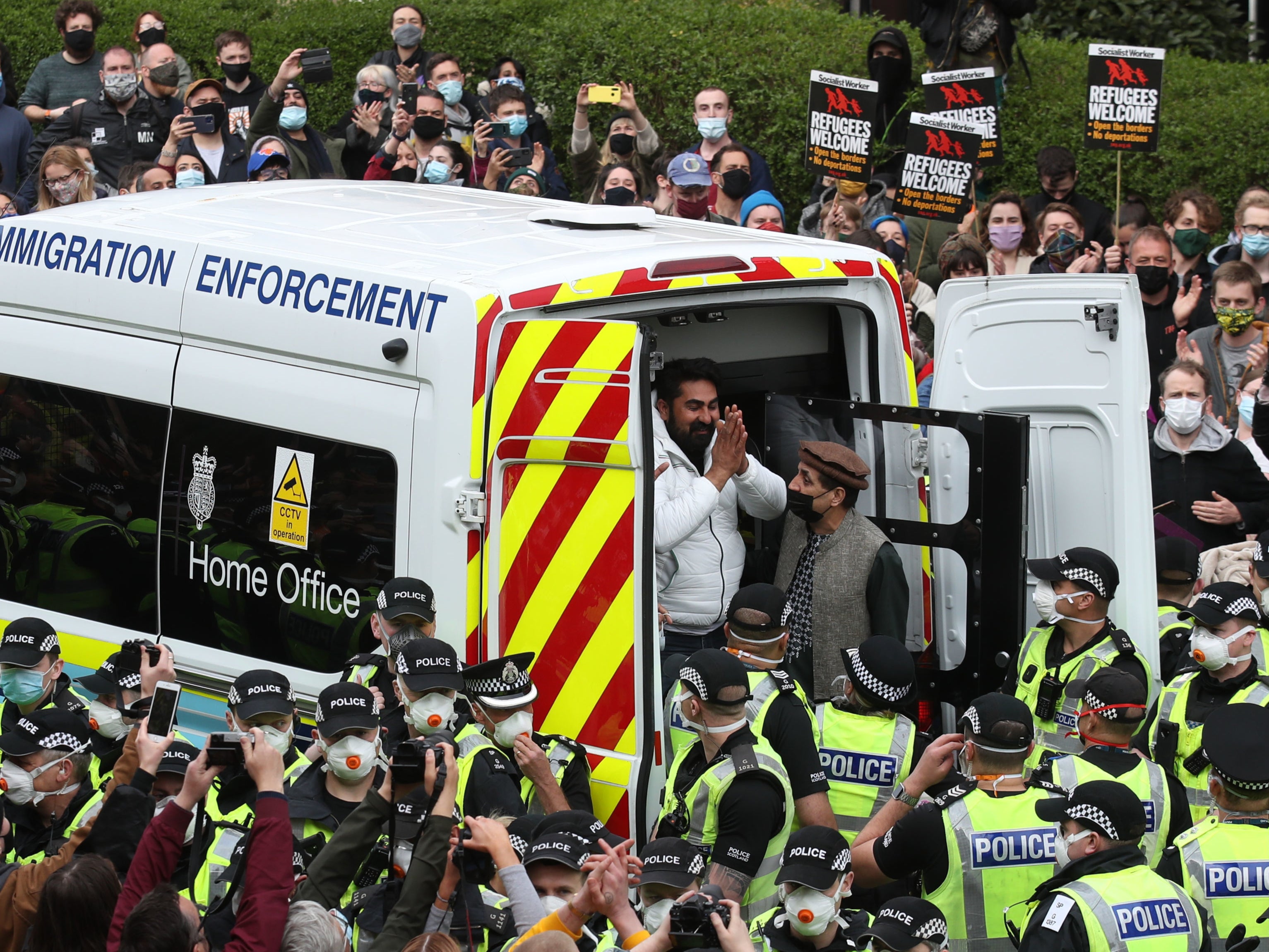 One of the two detained men thanks crowds as he is freed from the immigration van in Kenmure Street, Glasgow, on Thursday