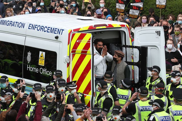 One of the men thanks crowds as he is freed from the immigration van