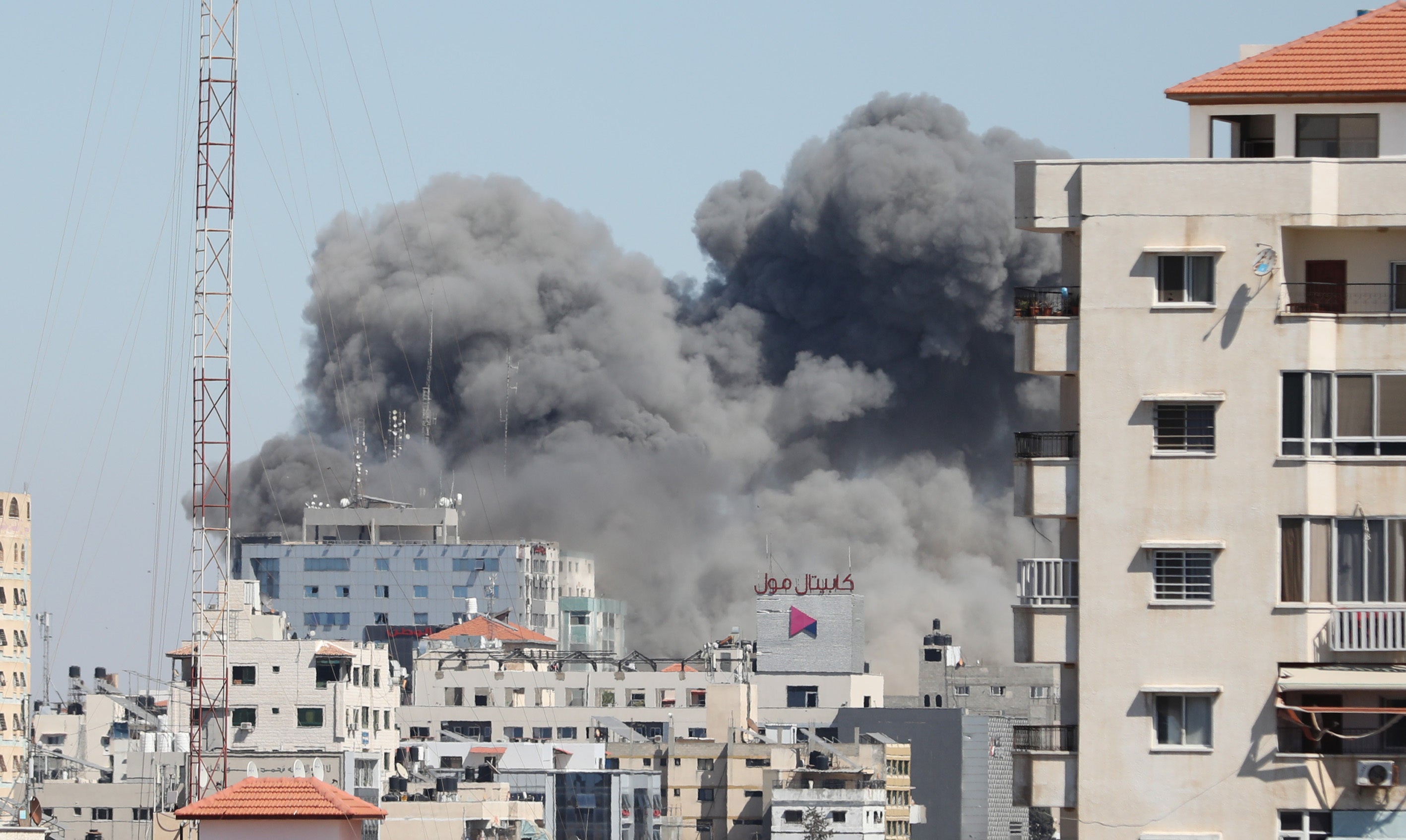 <p>Smoke rises after Israeli forces destroyed building in Gaza City where Al-Jazeera and Associated Press had their offices, on Saturday (15 May)</p>