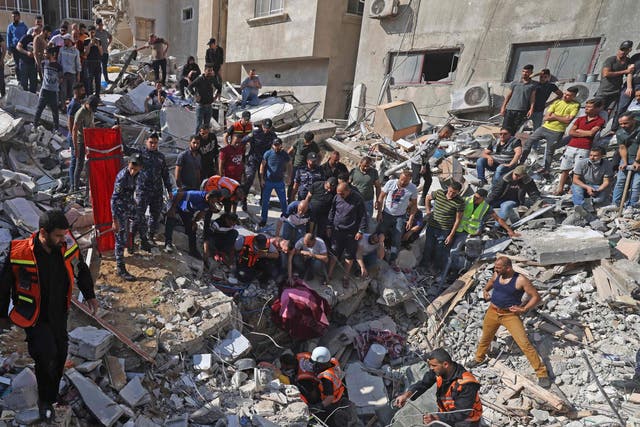 Paramédicos palestinos buscan sobrevivientes bajo los escombros de un edificio destruido en la ciudad de Gaza