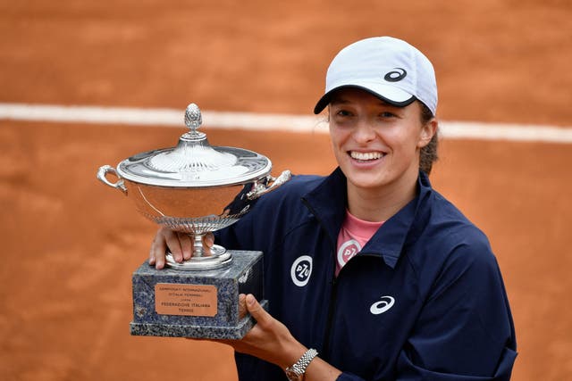 Iga Swiatek poses with the trophy after defeating Karolina Pliskova