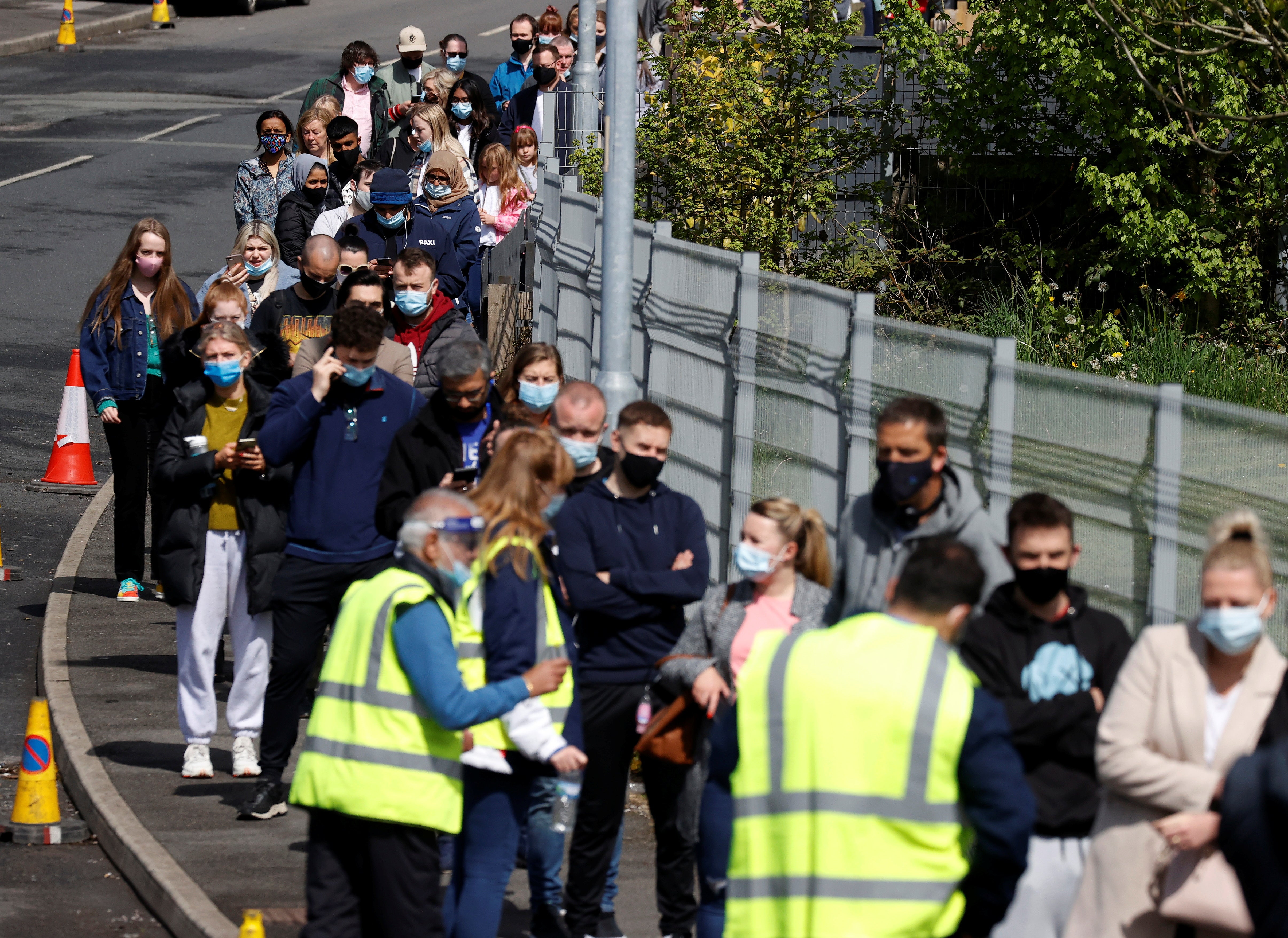 People line up outside a mobile vaccination centre in Bolton