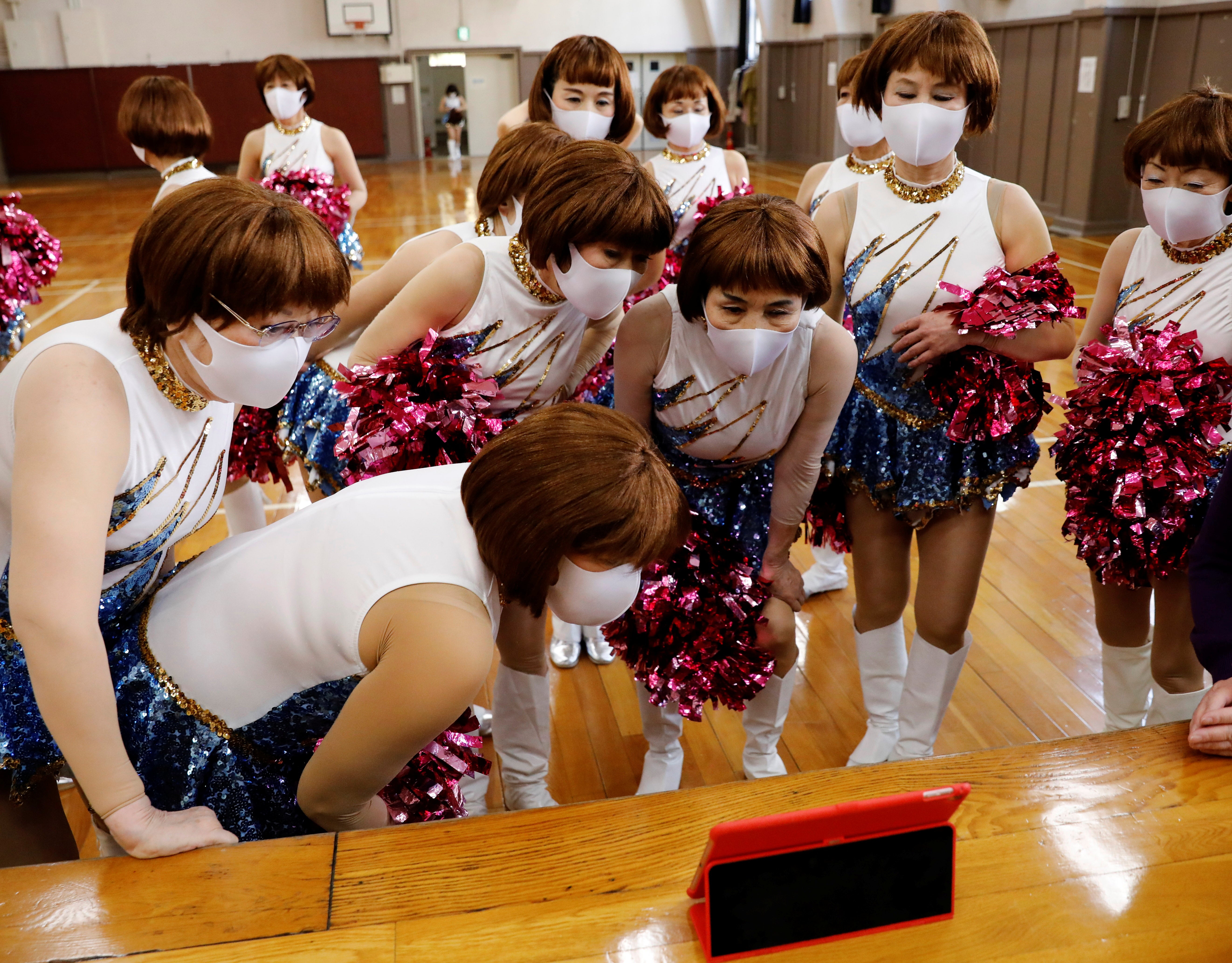 The senior cheer squad views a video of their routine