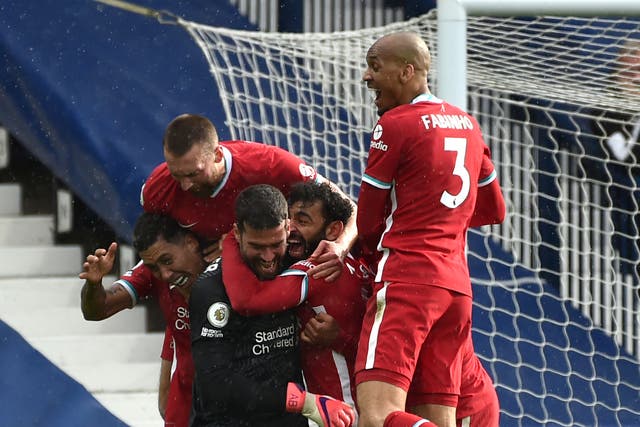 Liverpool players celebrate with Alisson after the goalkeeper’s late winner against West Brom