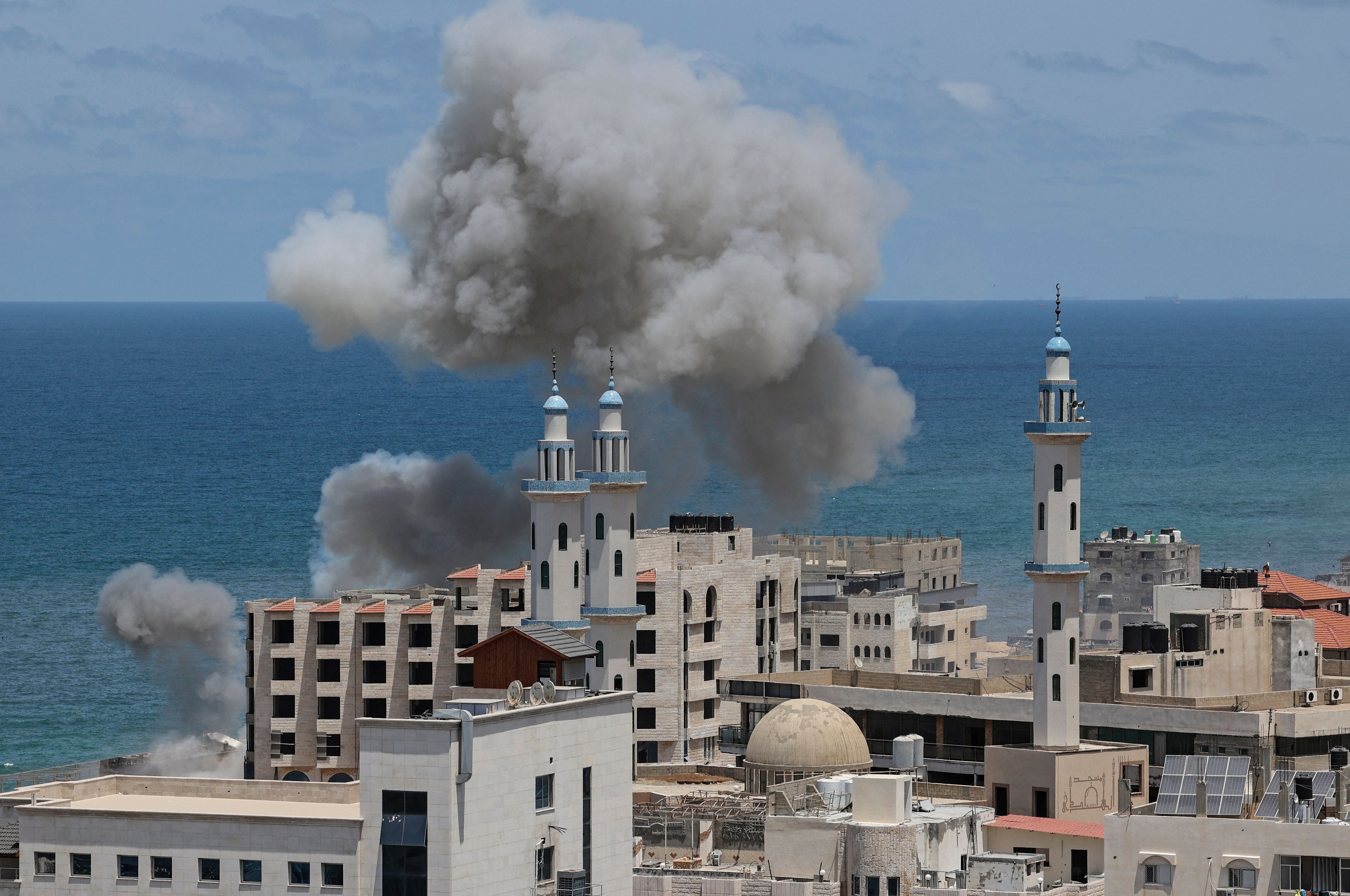 Smoke billows from the the area around the port of Gaza City following Israeli bombardment from the sea on May 17