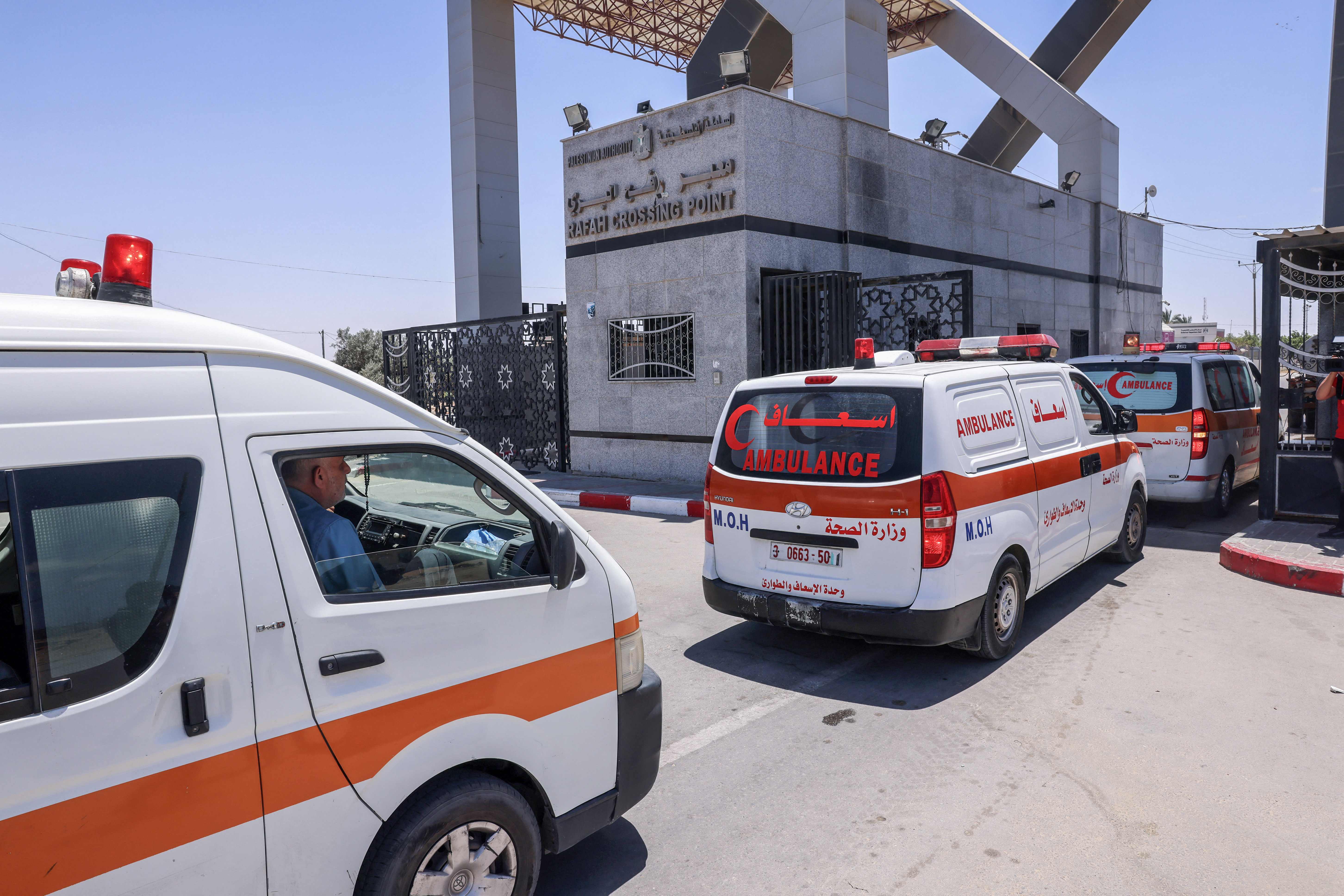 Ambulances evacuating injured Palestinians to Egypt for treatment arrive at the Rafah border crossing in the southern Gaza Strip