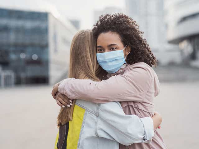 Two people embrace each other during the pandemic