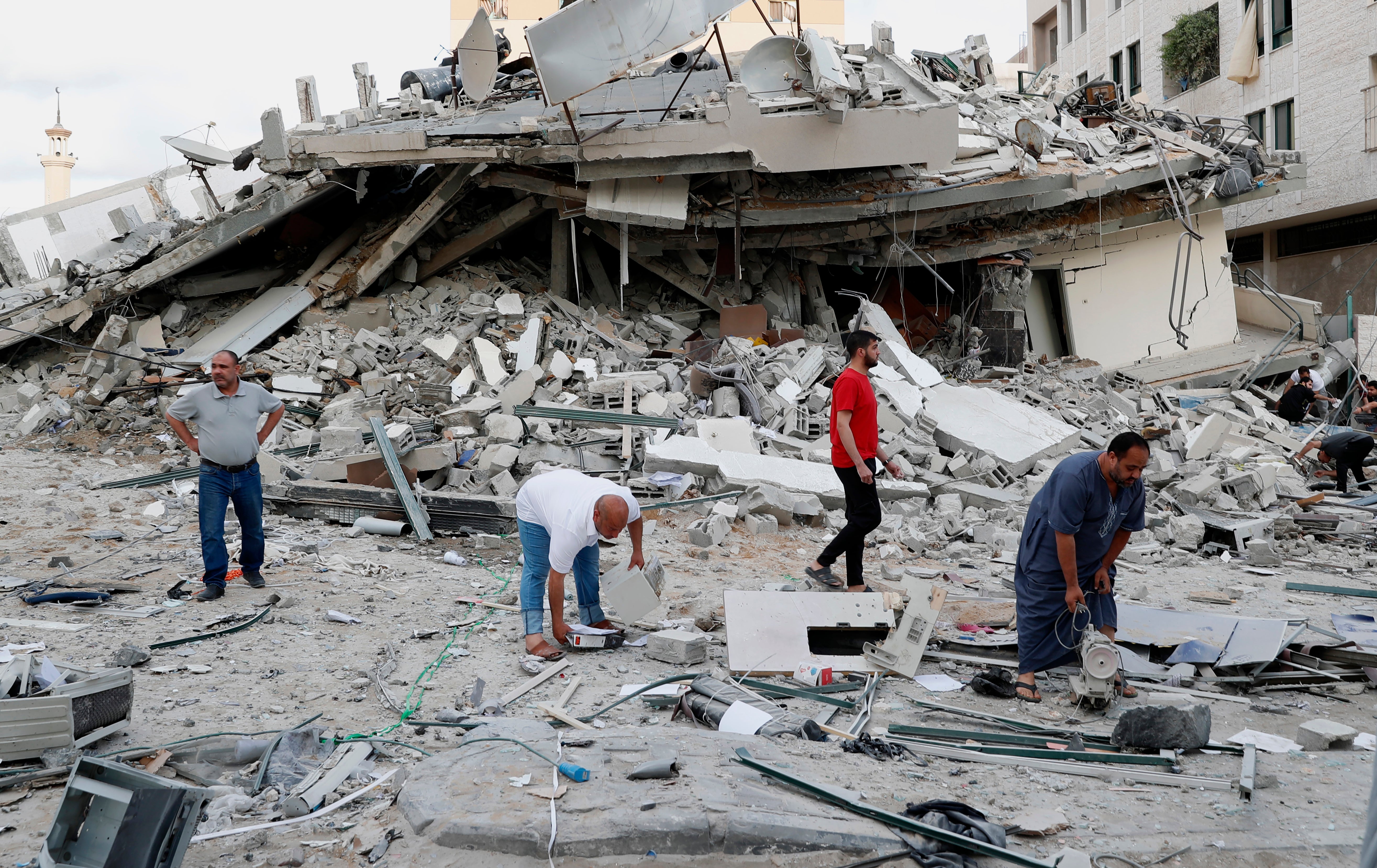 People inspect the rubble of destroyed residential building that was hit by an Israeli airstrike, in Gaza City, Monday, May 17, 2021