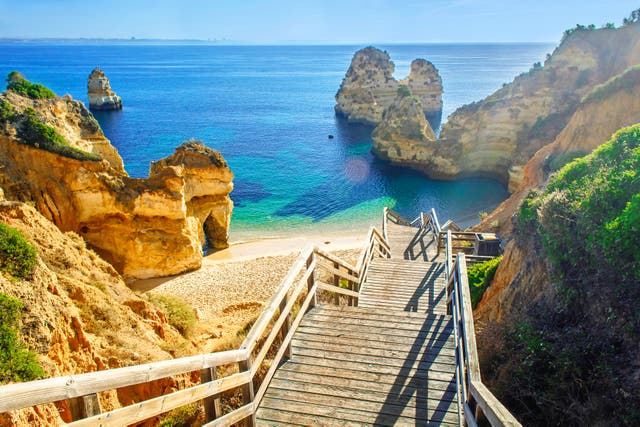 <p>A wooden footbridge leads to the beach at Praia do Camilo in Portugal’s Algarve region, on the UK’s ‘green list’</p>