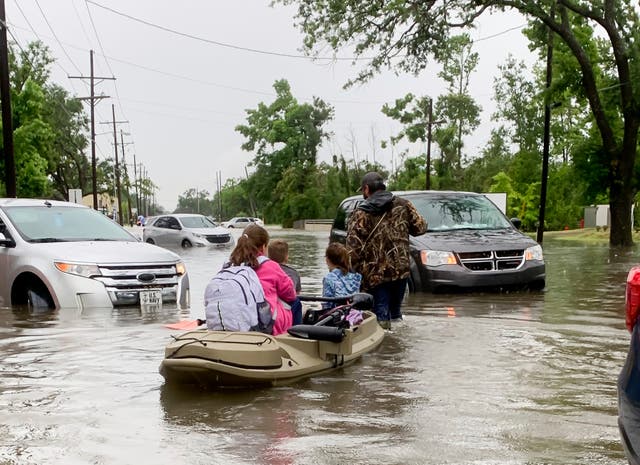 <p>Parents use boats to pick up students from schools after nearly a foot of rain fell in Lake Charles, Louisiana on 17 May.</p>