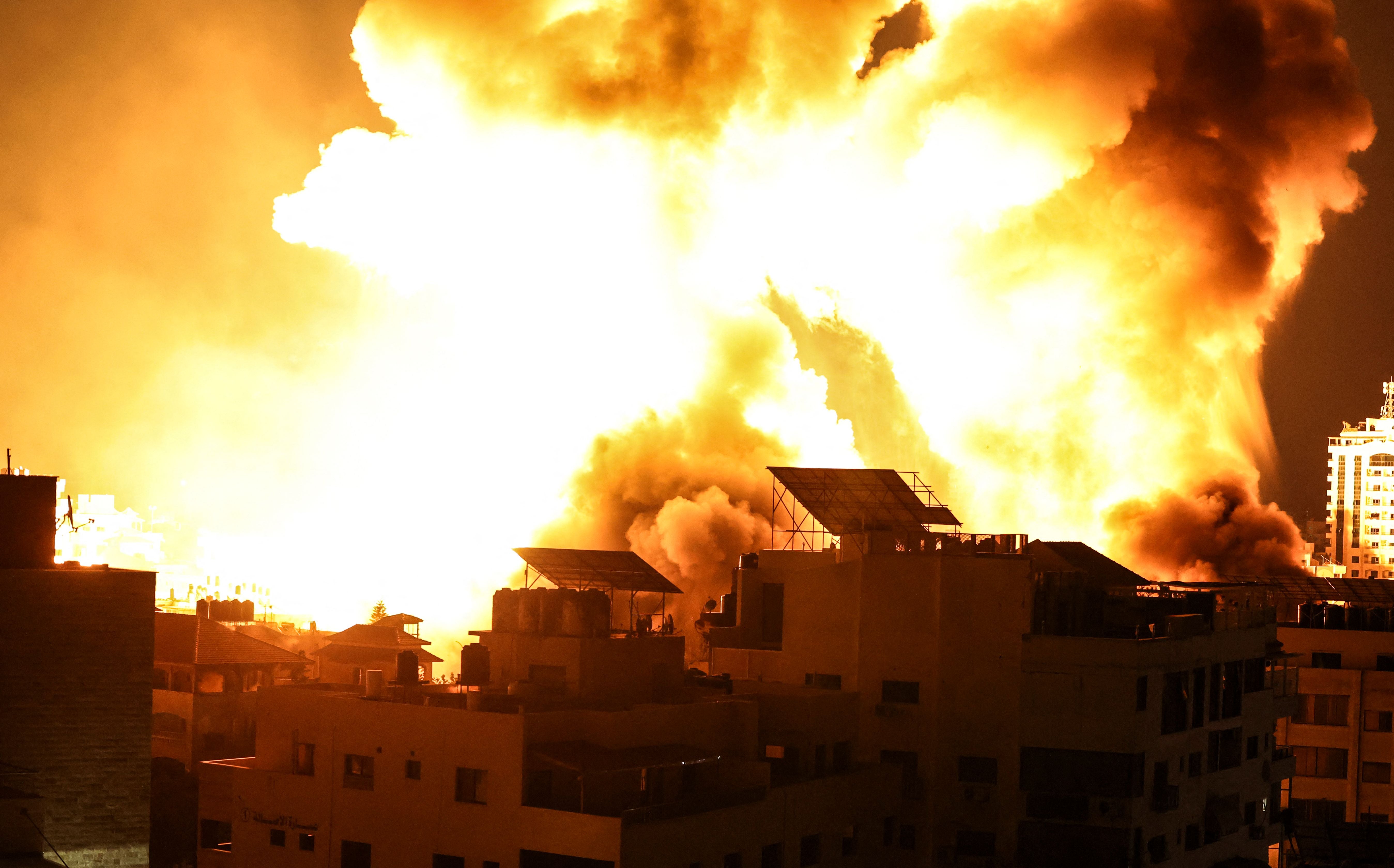 A ball of fire explodes above buildings in Gaza City as Israeli forces shell the Palestinian enclave, early on May 18, 2021