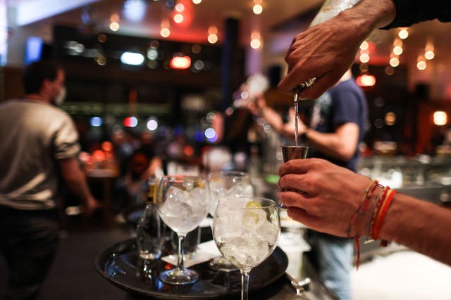 A waiter serves a cocktail at a bar on the eve of the mandatory closure of bars in Brussels