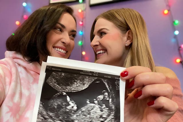 Rose and Rosie holding up their baby scan