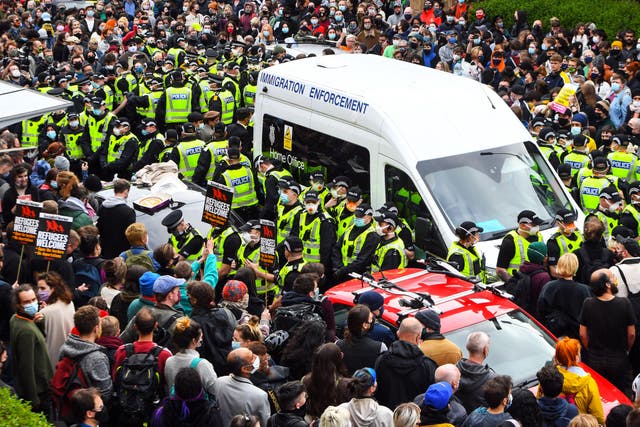 <p>Protesters surround an Immigration Enforcement van to stop it from departing after individuals were detained in Glasgow on 13 May 2021</p>