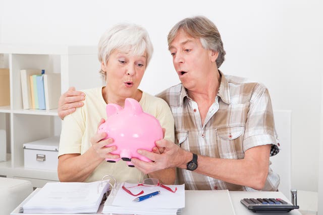 Senior Couple Saving Money In The Pink Piggybank