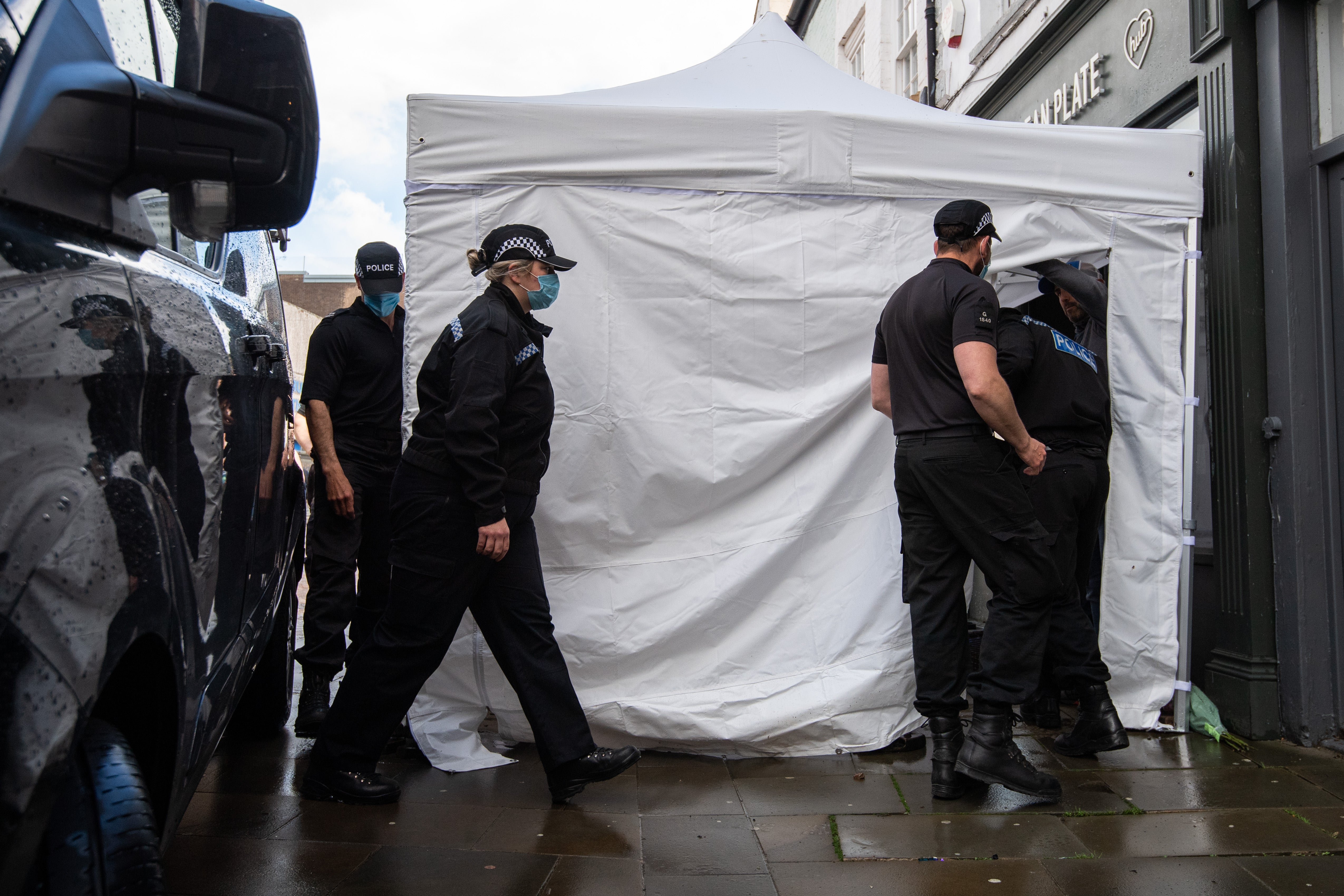 Police officers enter the Clean Plate Cafe on Southgate Street