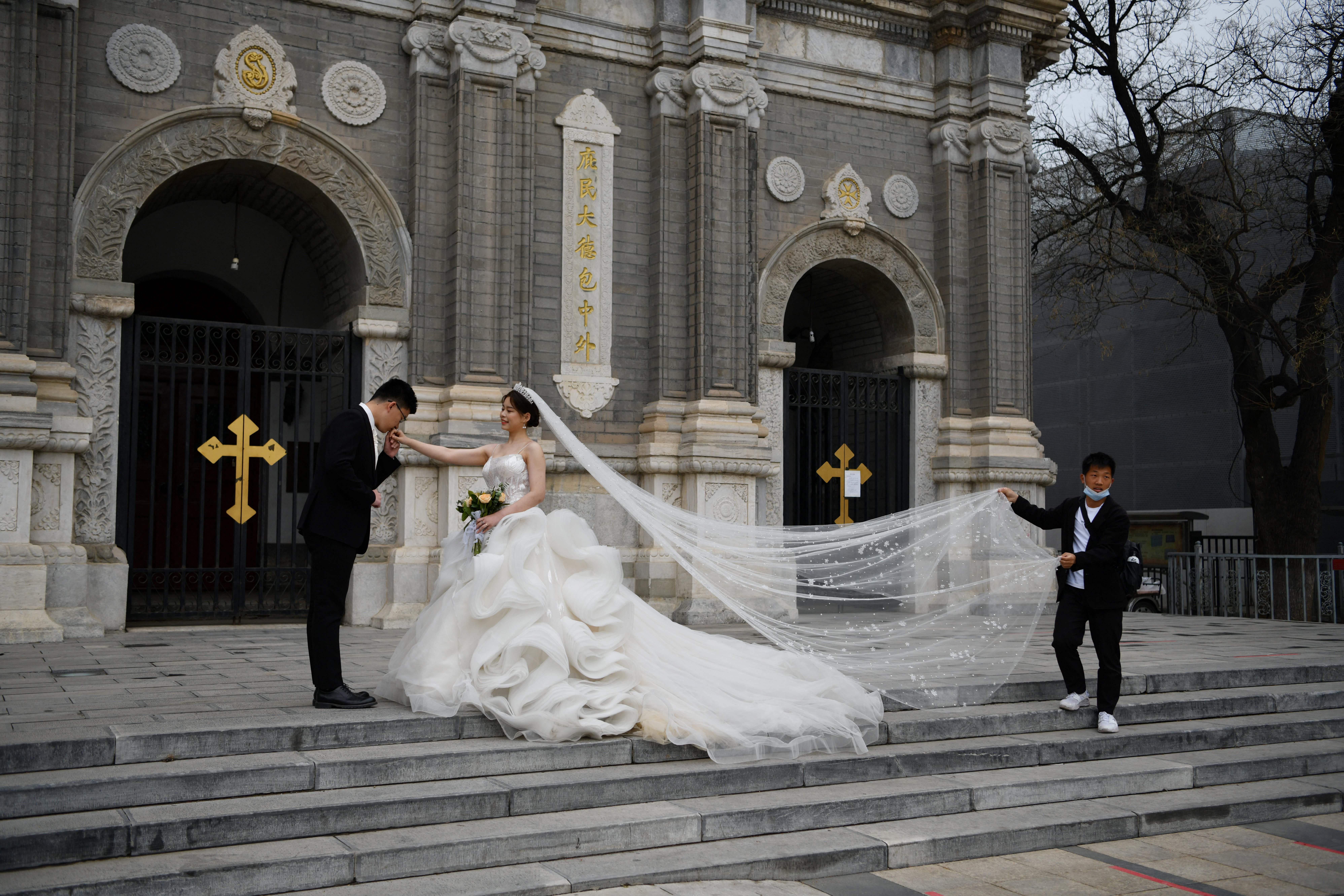 A couple poses for wedding photos outside St Joseph’s Church, also known as Wangfujing Catholic Church, in Beijing