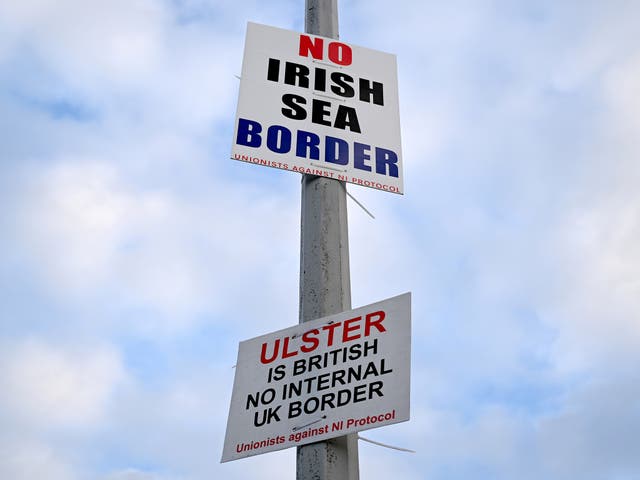 <p>Signs opposed to the Irish Sea border affixed to a lamp post in Port of Larne, Northern Ireland</p>