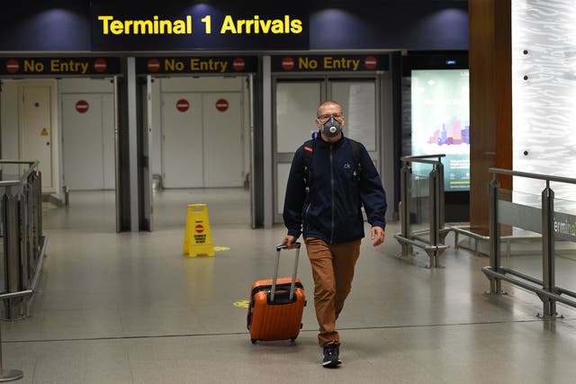 A passenger wearing PPE to prevent the spread of Covid-19, arrives at Terminal 1 of Manchester Airport in northern England, on 8, June, 2020.