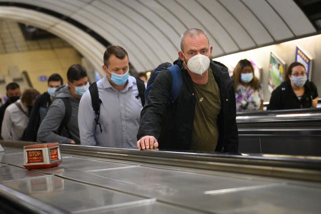 Commuters wear face masks as they pass through Vauxhall underground station on the first day of their mandatory use while travelling on public transport, on 15 June, 2020 in London, England. 