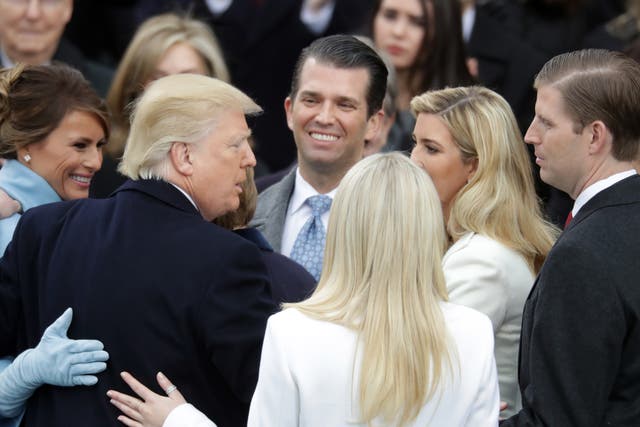<p>President Donald Trump hugs his family after taking the oath of office, on the West Front of the US Capitol on 20 January, 2017</p>