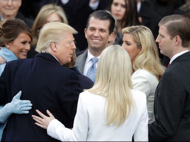 <p>President Donald Trump hugs his family after taking the oath of office, on the West Front of the US Capitol on 20 January, 2017</p>