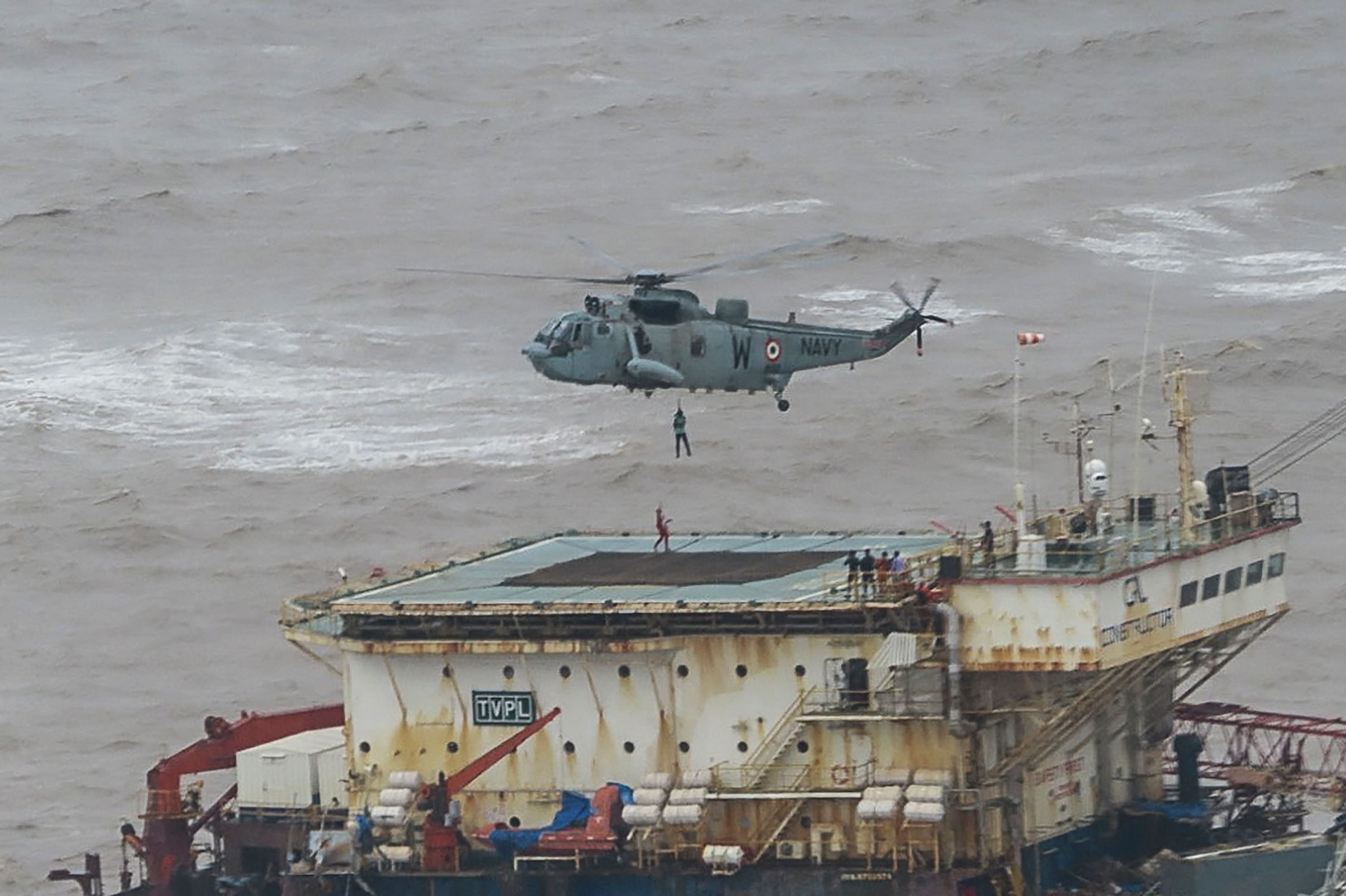 Stranded workers from a barge, which had gone adrift amidst heavy rain and strong winds due to Cyclone Tauktae, being airlifted by naval personnel