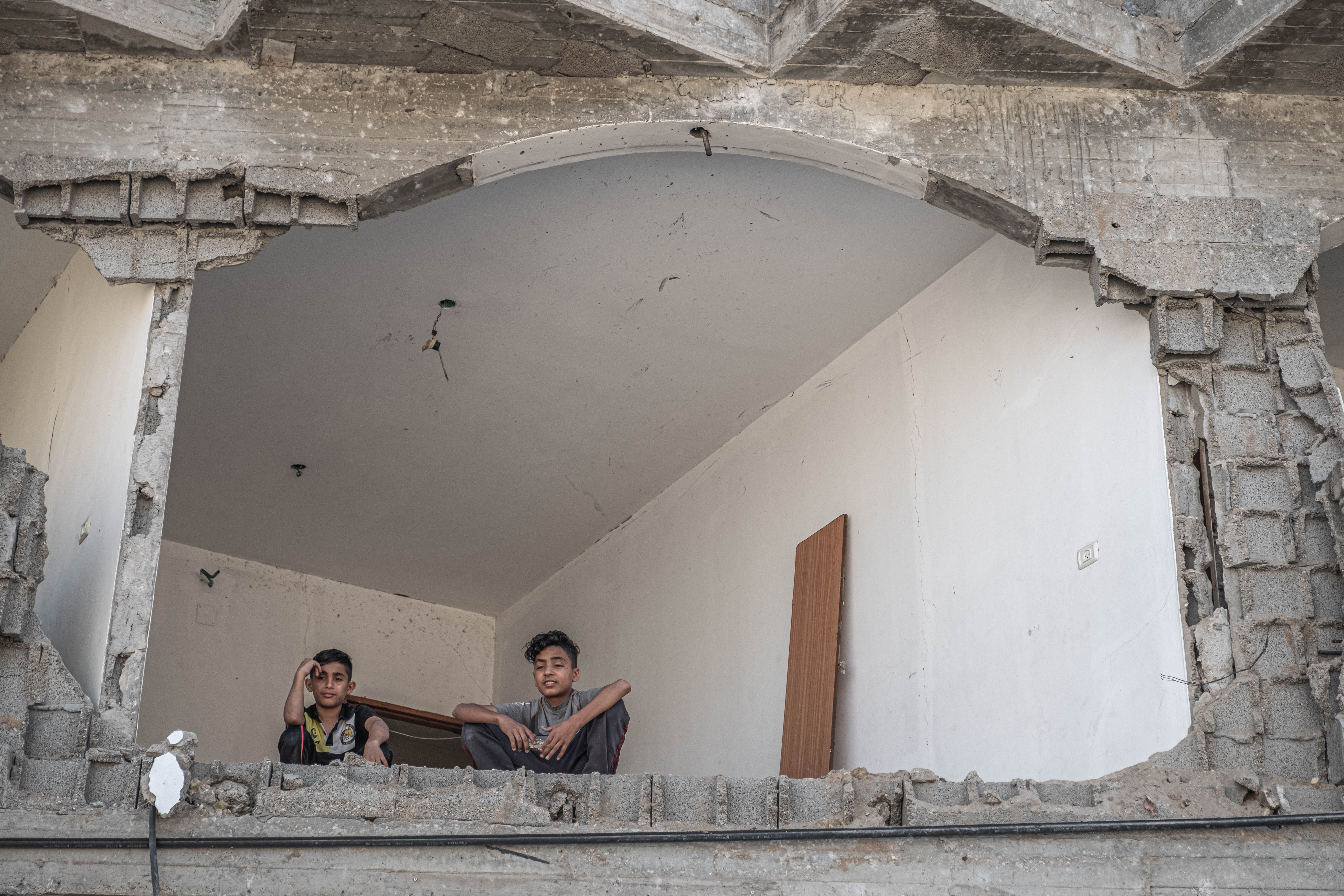 Two boys sit inside a damaged building in northern Gaza City