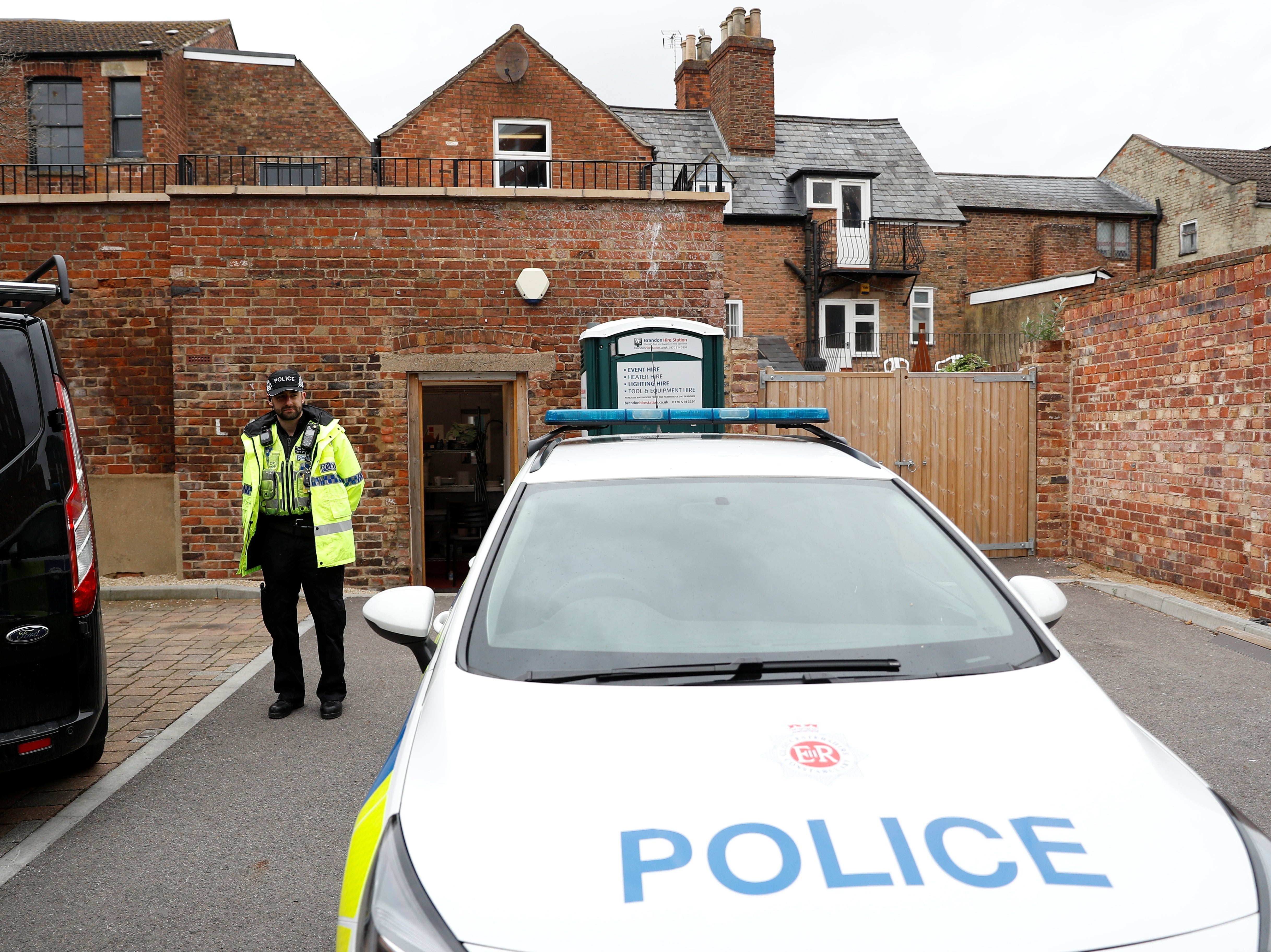 Police guard the rear entrance to the excavation site at The Clean Plate cafe in Gloucester on Thursday