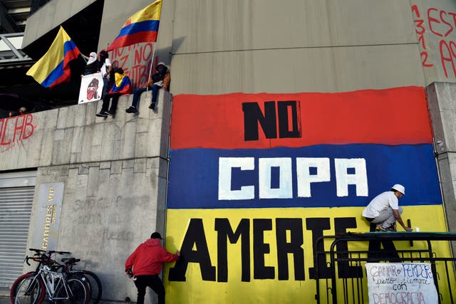 <p>A protester in Colombia calls for the tournament to be moved from the country</p>