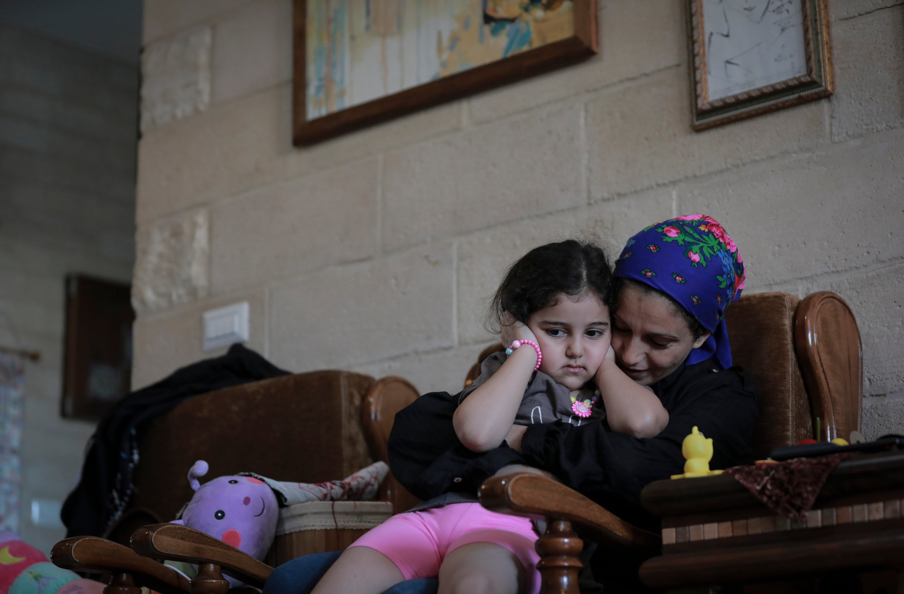 Maha Al-Daya embraces daughter Yafa after hearing the sound of the bombing in Gaza