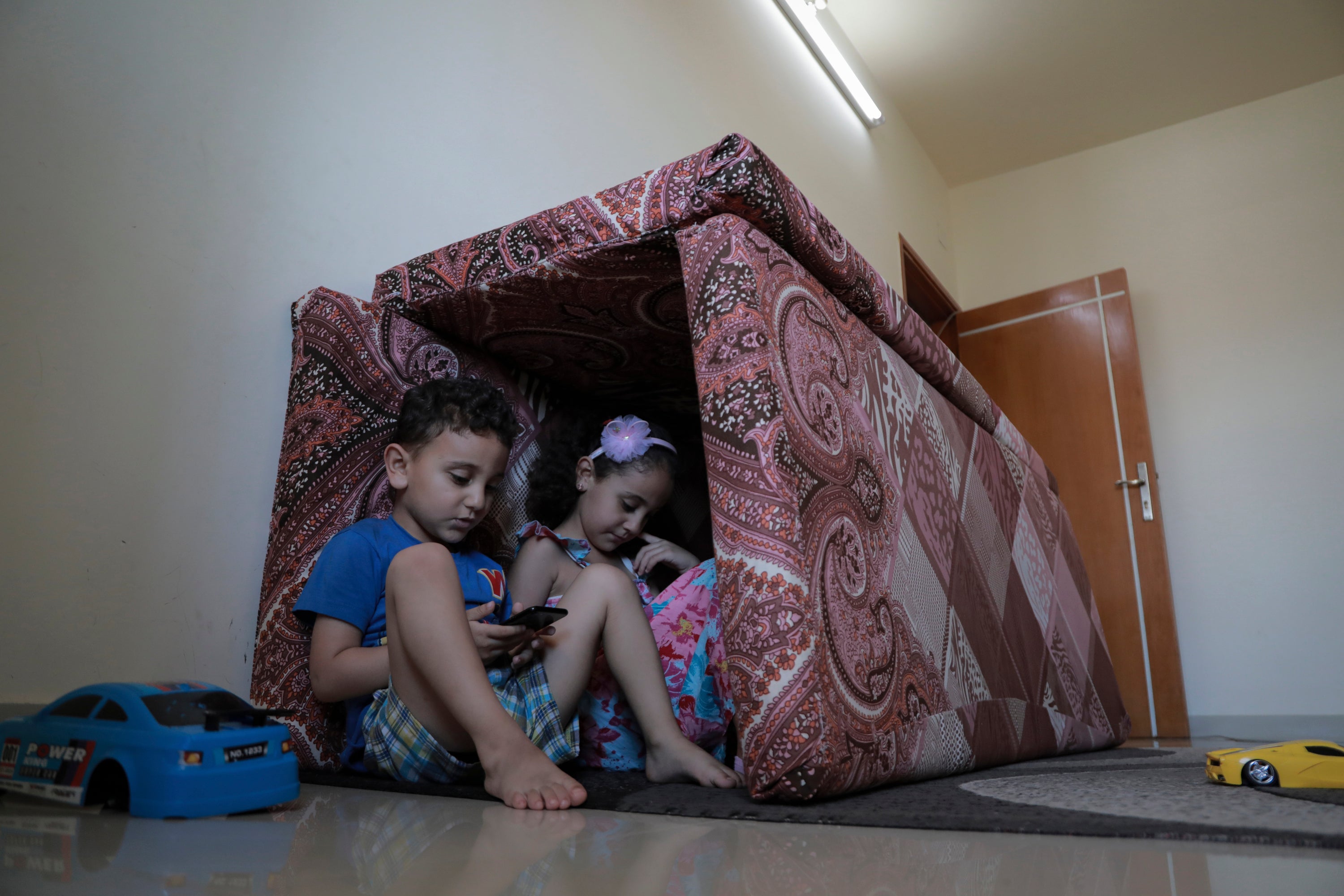 Shelter and play: Jamal Mghames and his sister, Joury, with their fort of cushions at home in Gaza City during the recent bombing