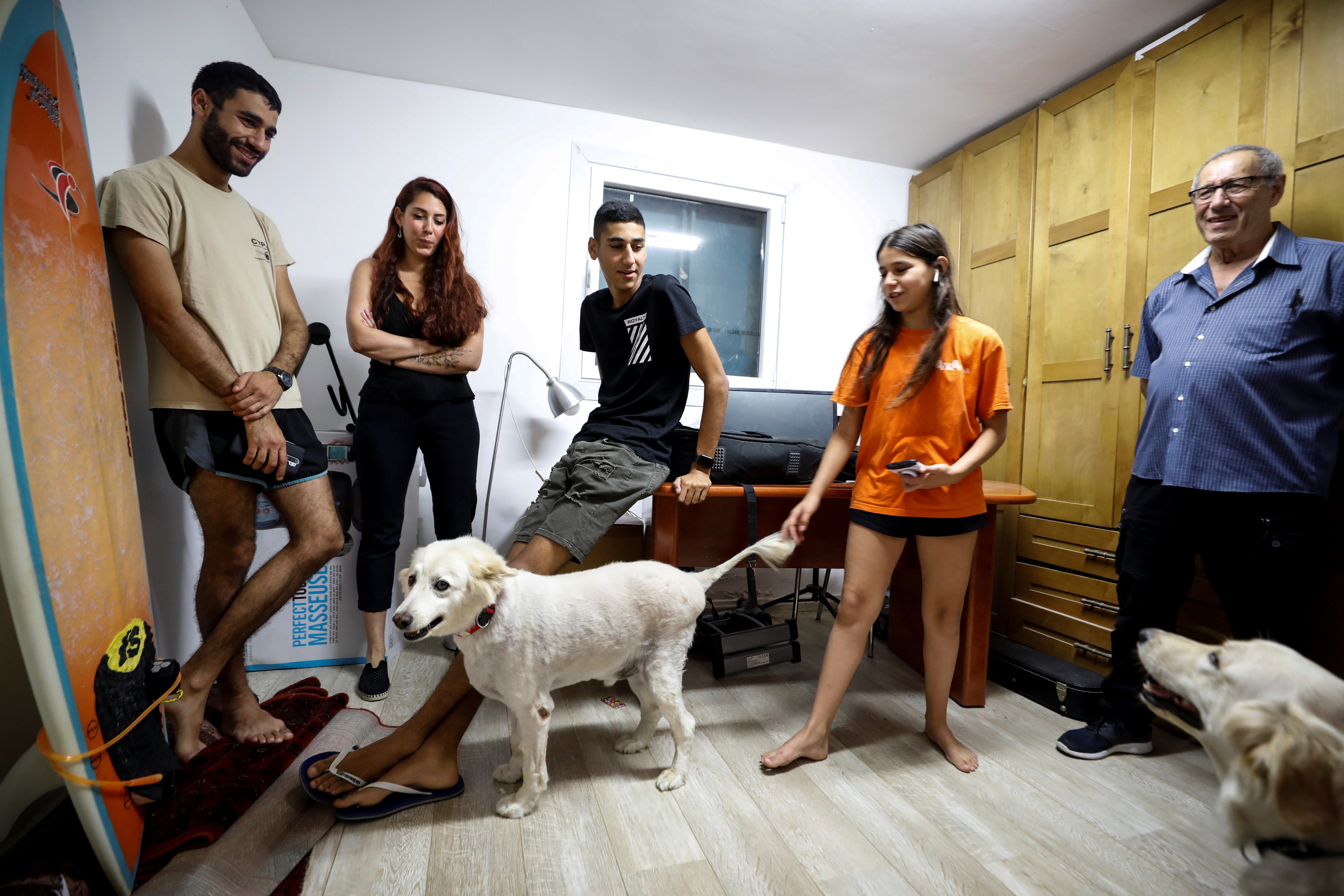 Members of the Vaizel family and their dogs, stand inside a bomb shelter in their house in Ashkelon