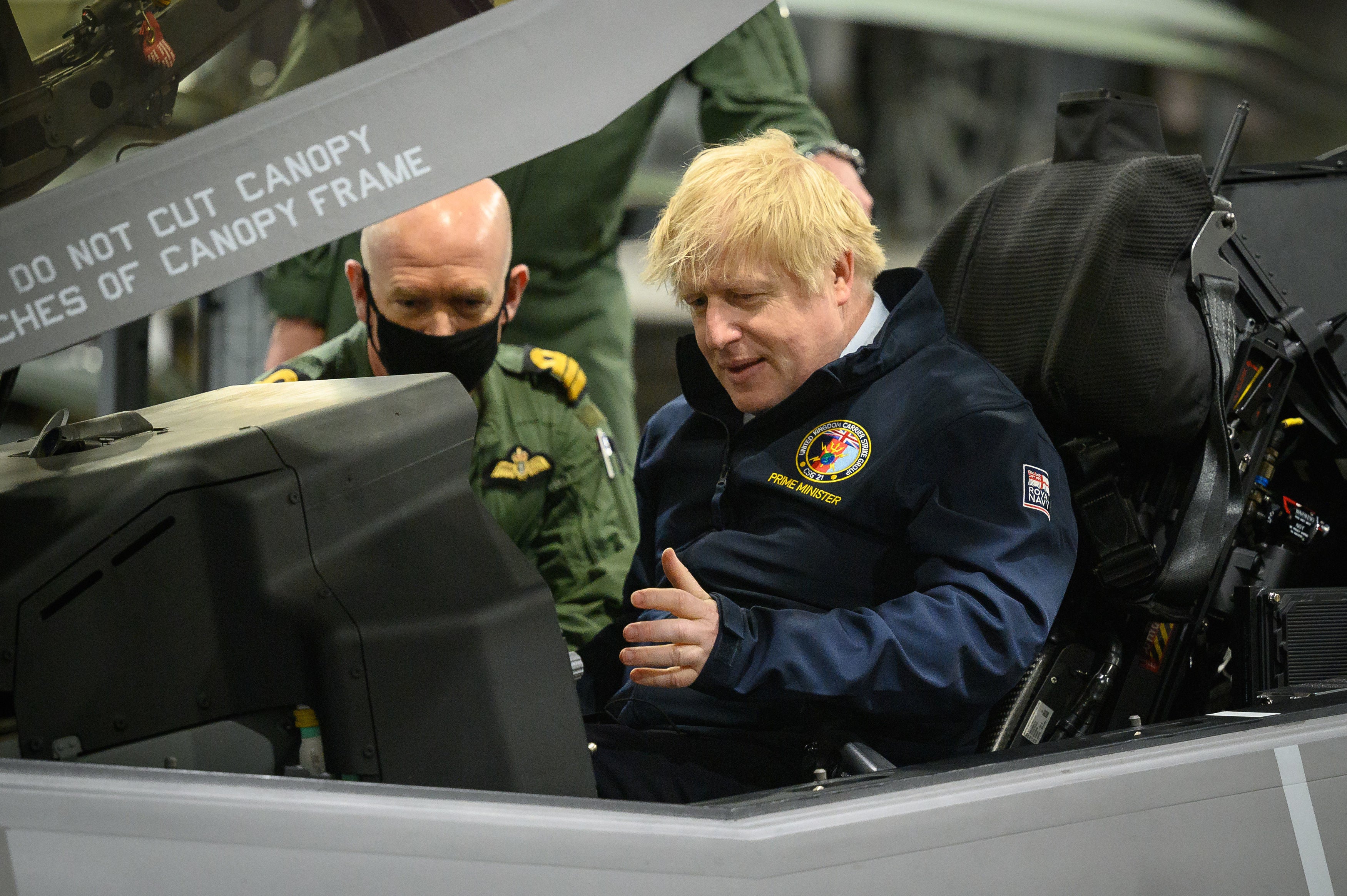 Prime Minister Boris Johnson sits in the cockpit of an Lockheed Martin F-35 during a visit to a UK aircraft carrier on Friday May 21, 2021.
